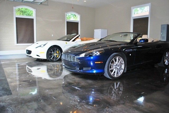 Two sports cars are parked in a garage.