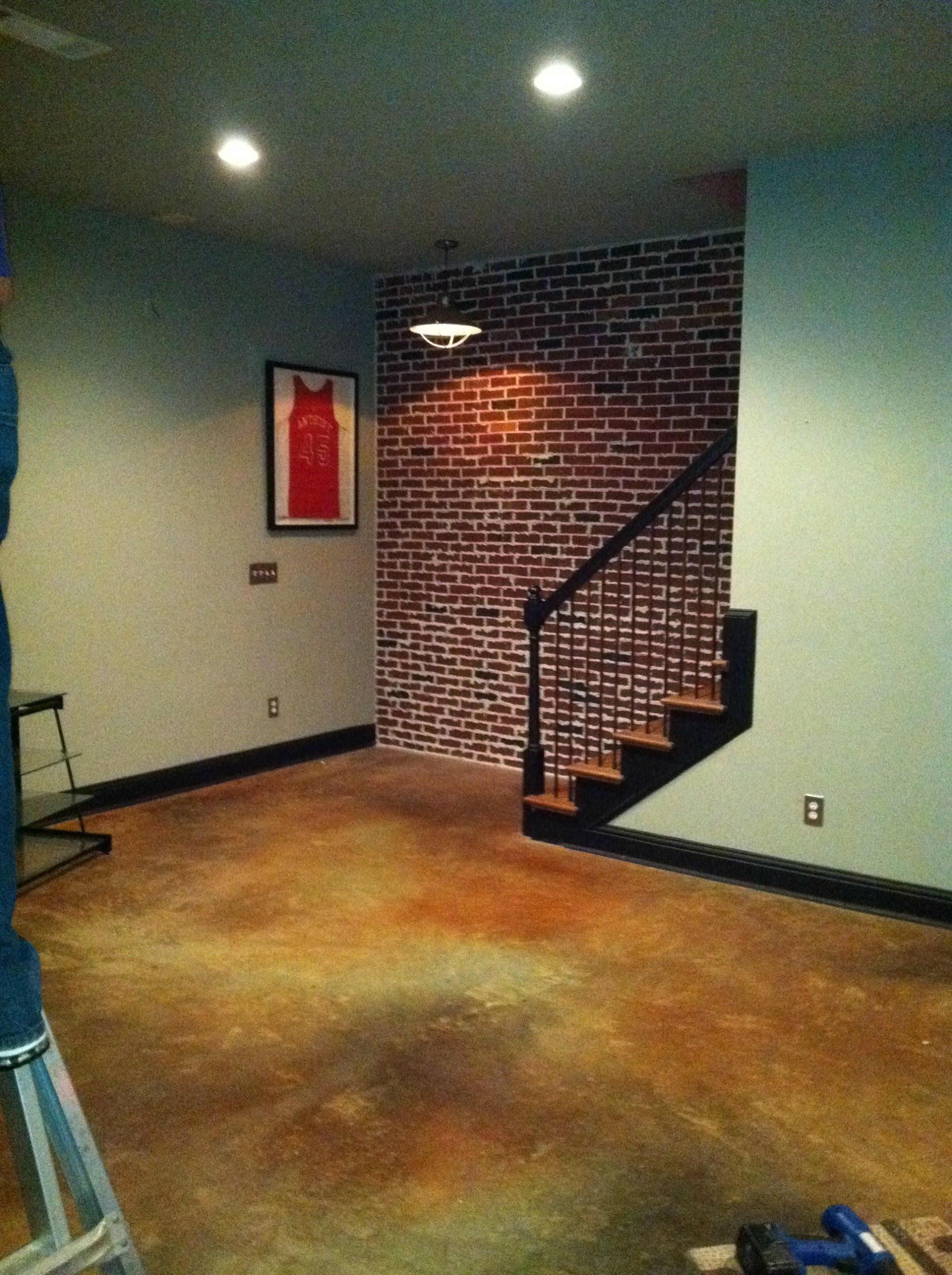 A room with a staircase and a brick wall