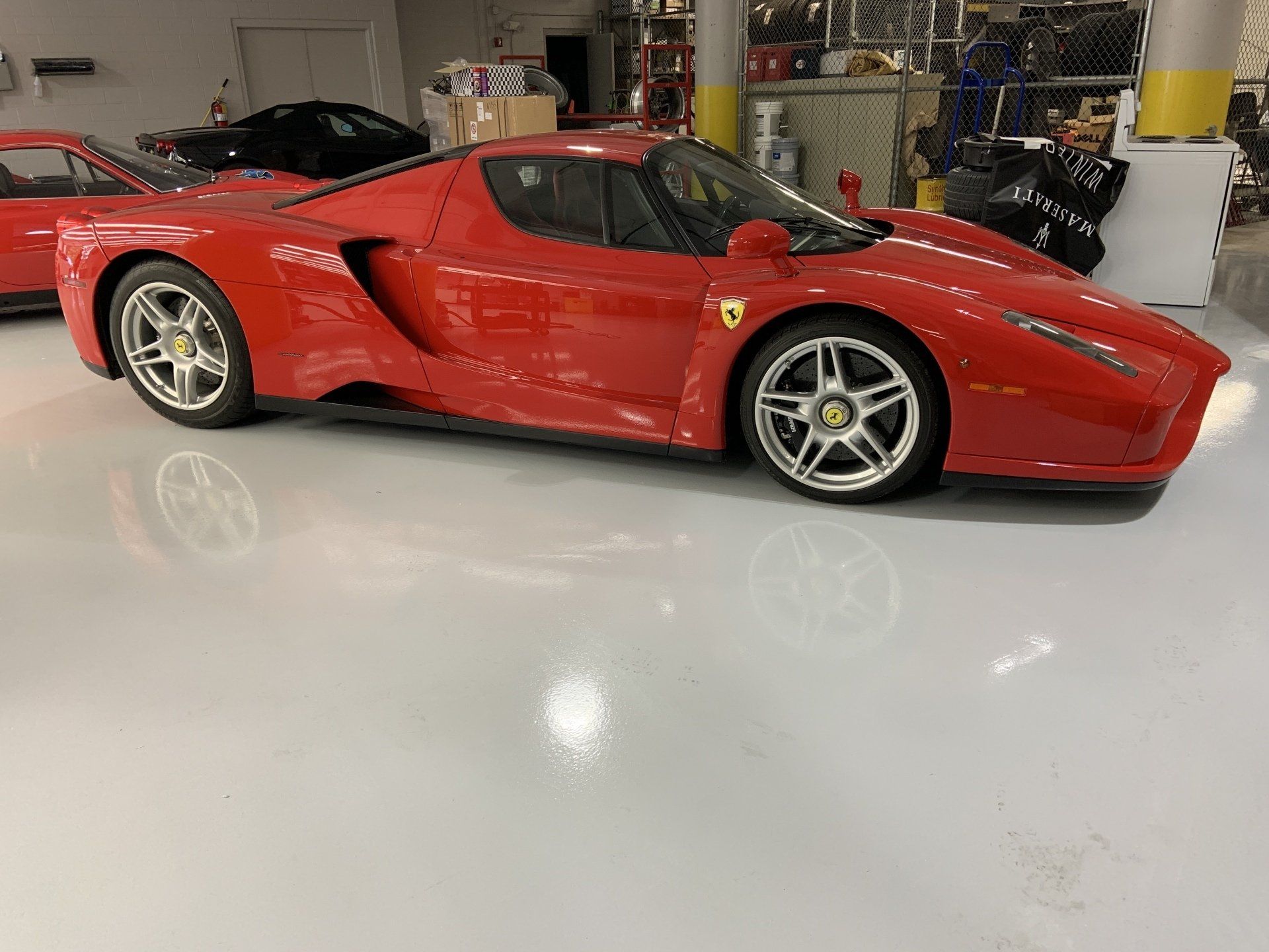 A red ferrari is parked in a garage.