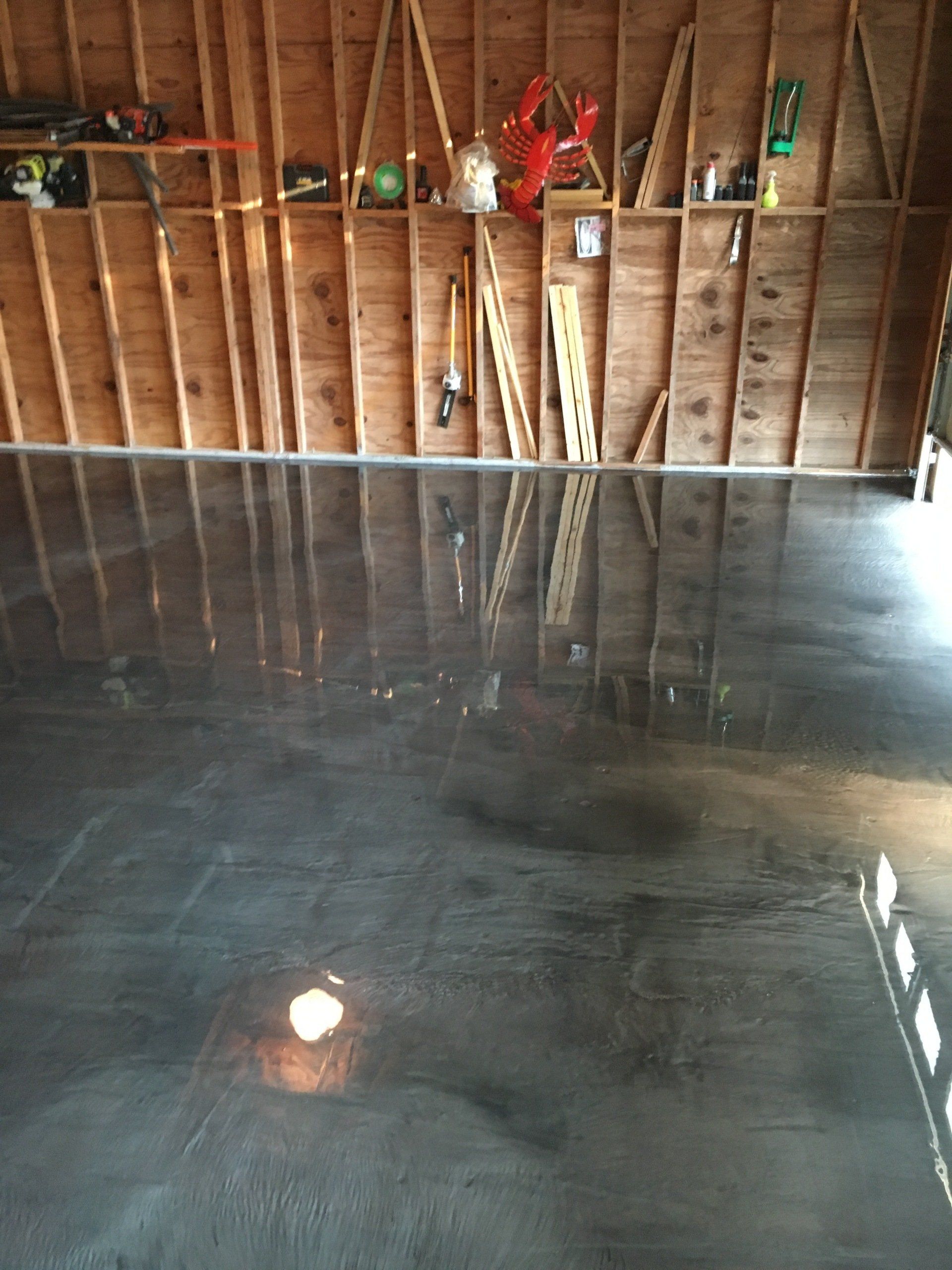 A garage with a shiny concrete floor and wooden walls
