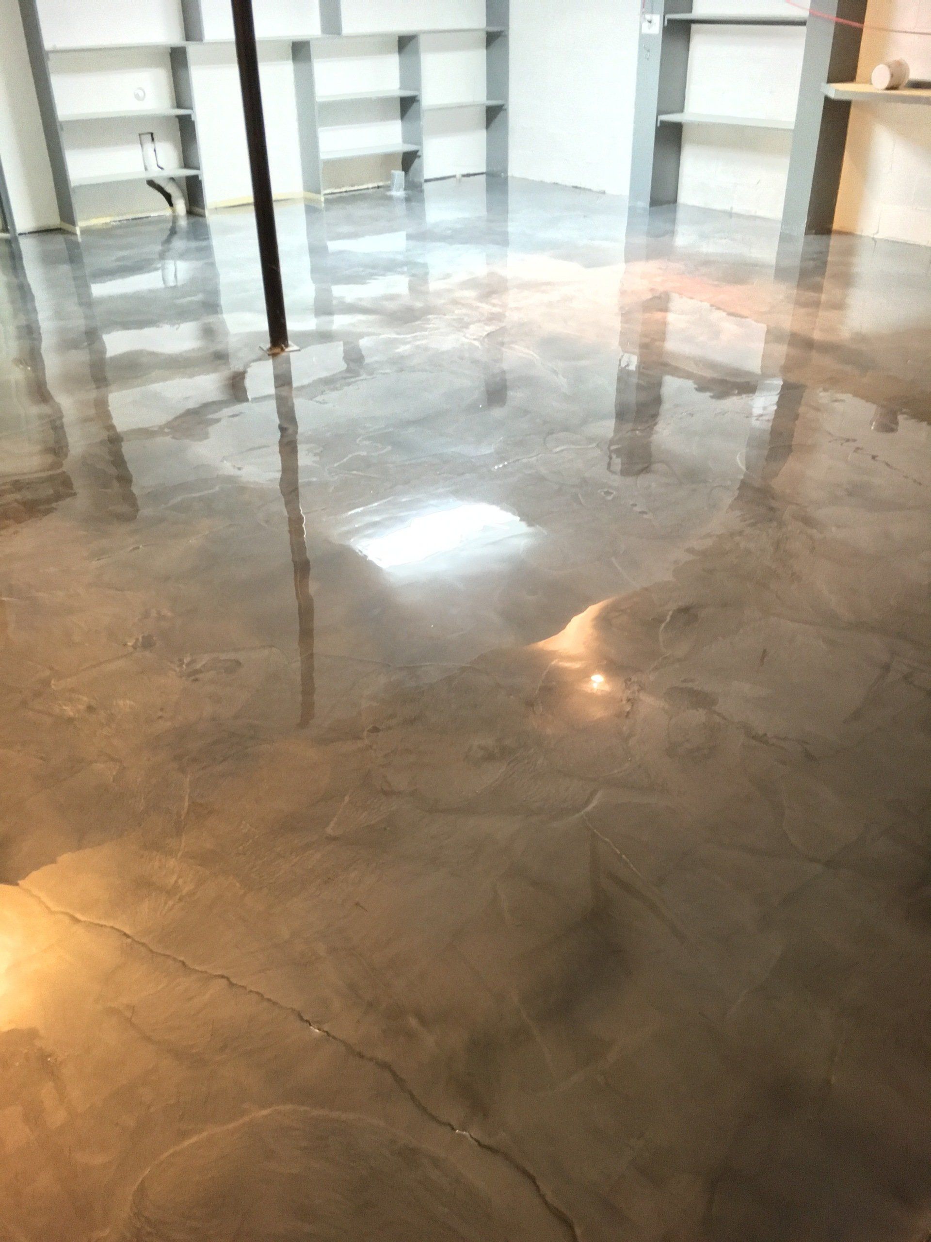 A shiny concrete floor in a room with shelves