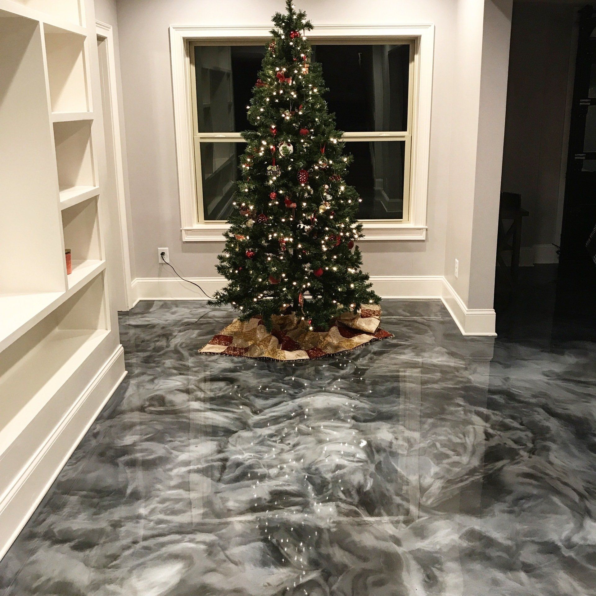 A christmas tree in a living room with a metallic floor