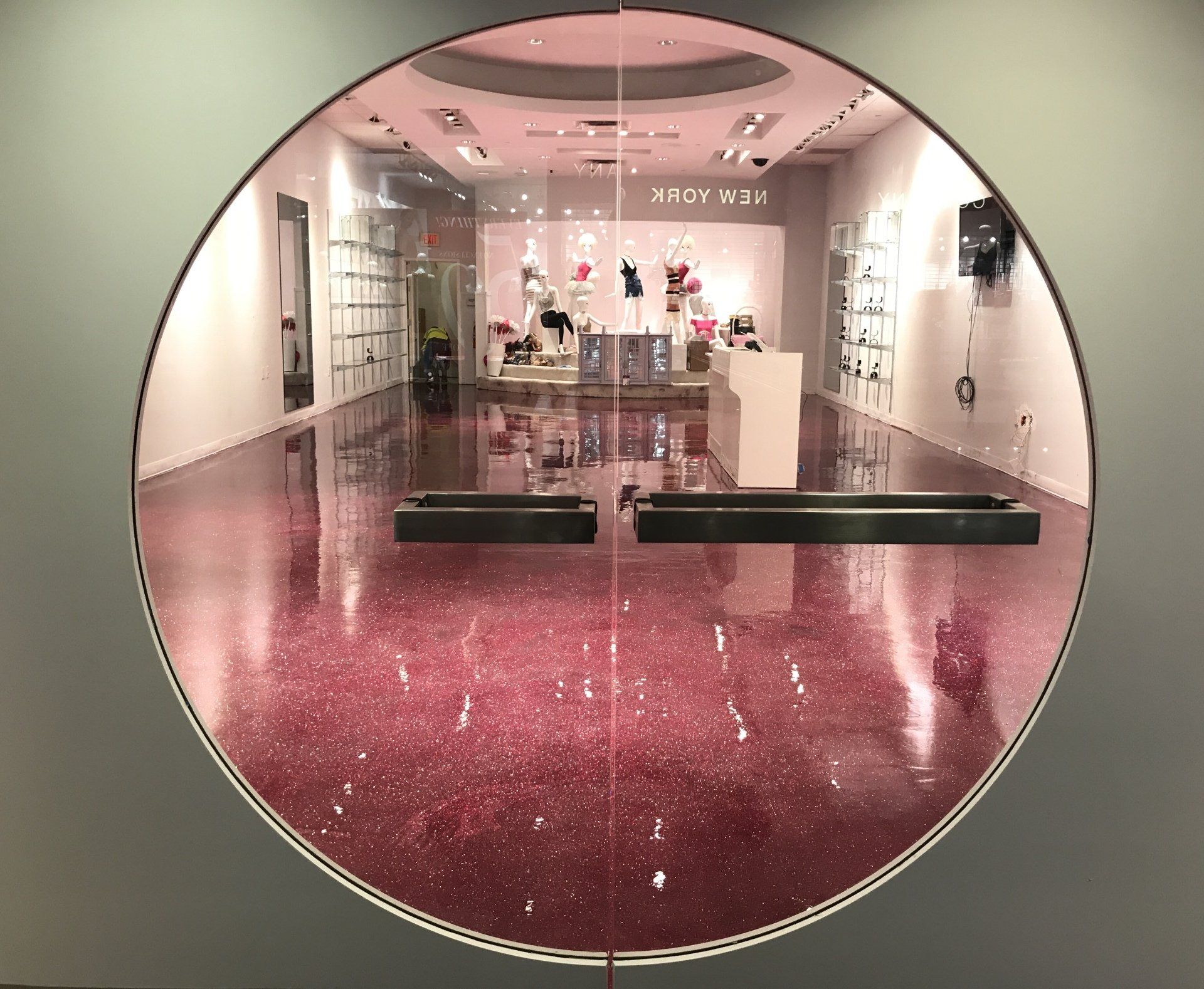 A store with a pink floor and a round window