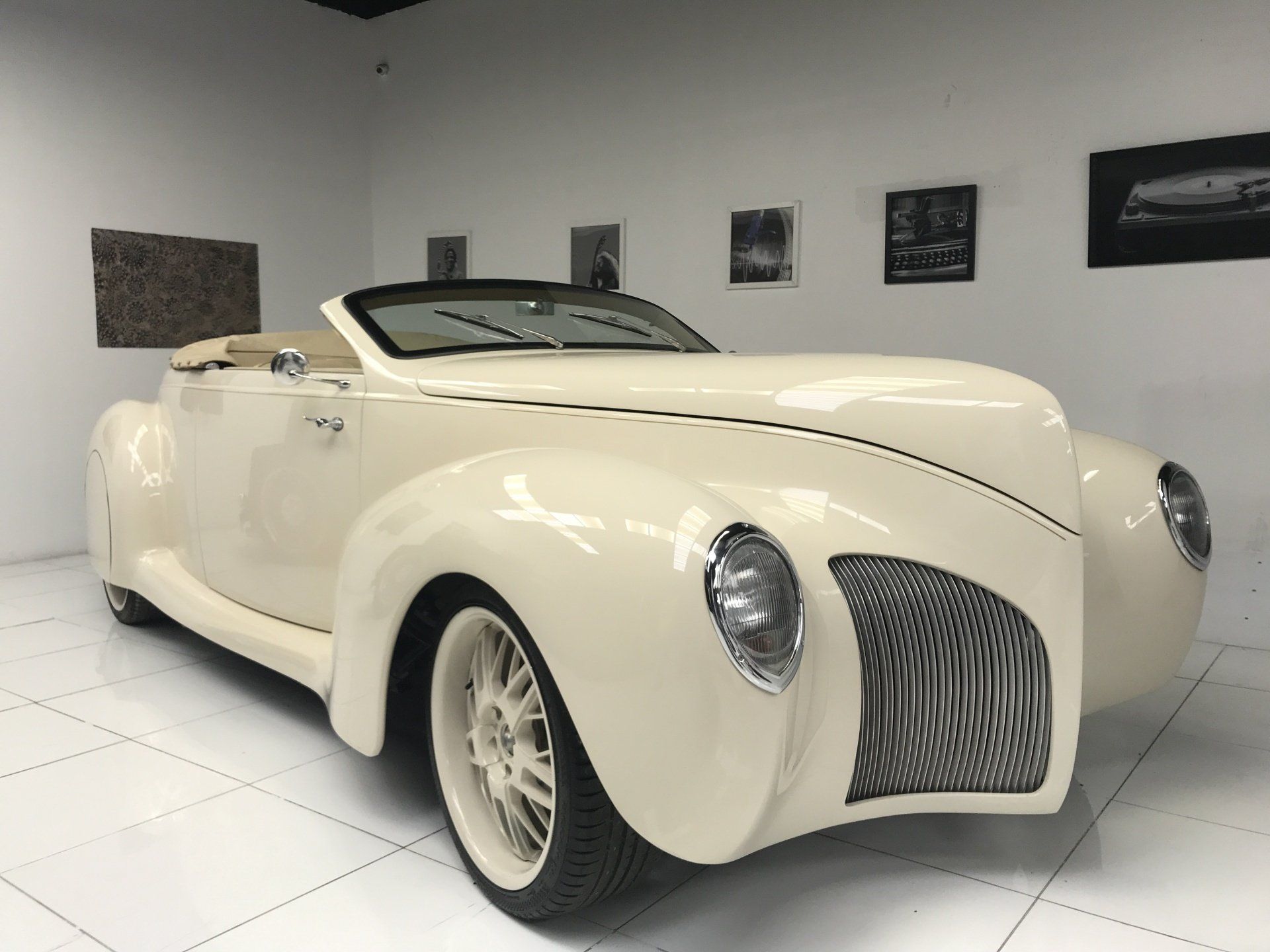 A white convertible car is parked in a garage.