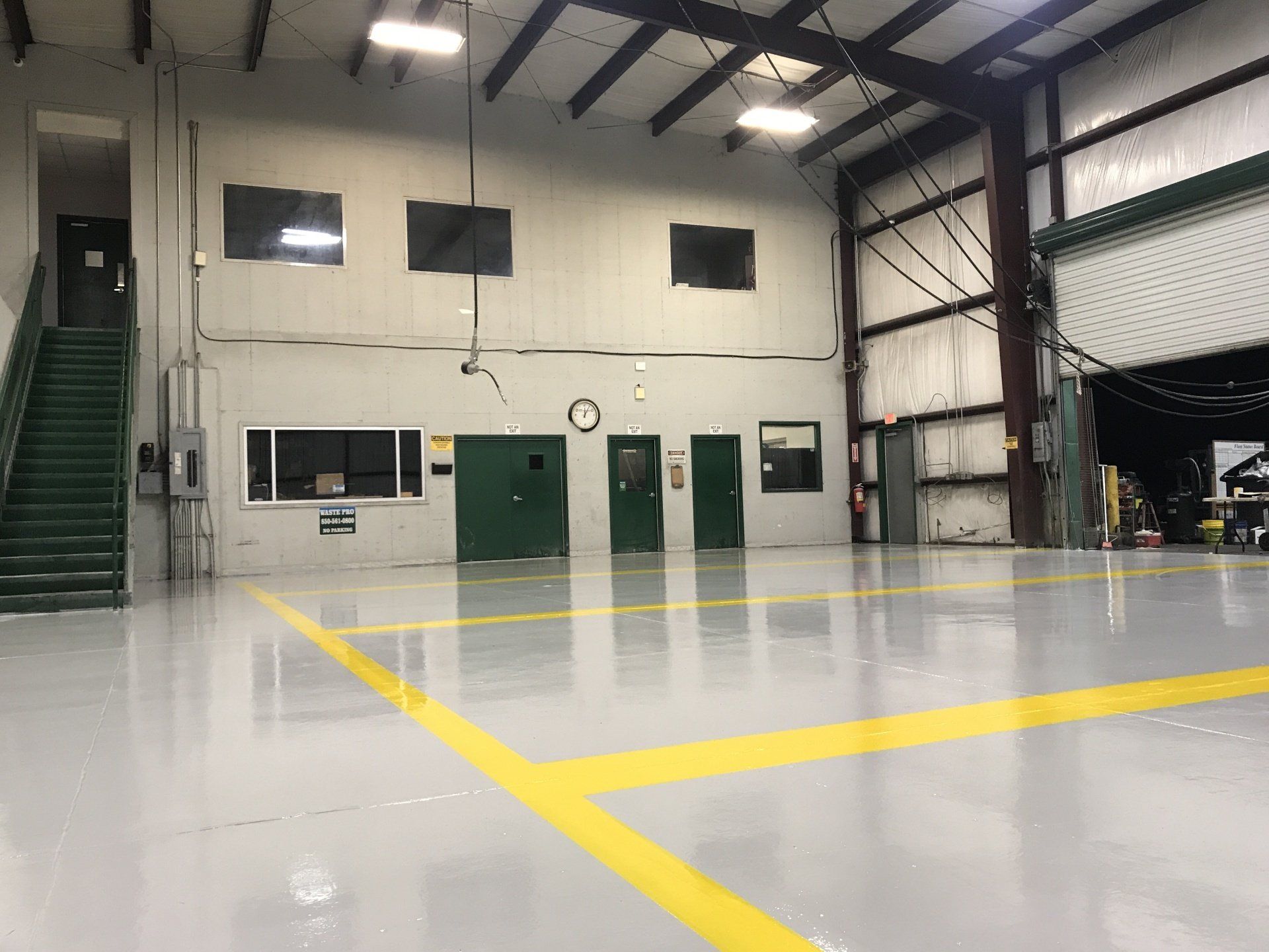 A large empty warehouse with a yellow line on the floor.