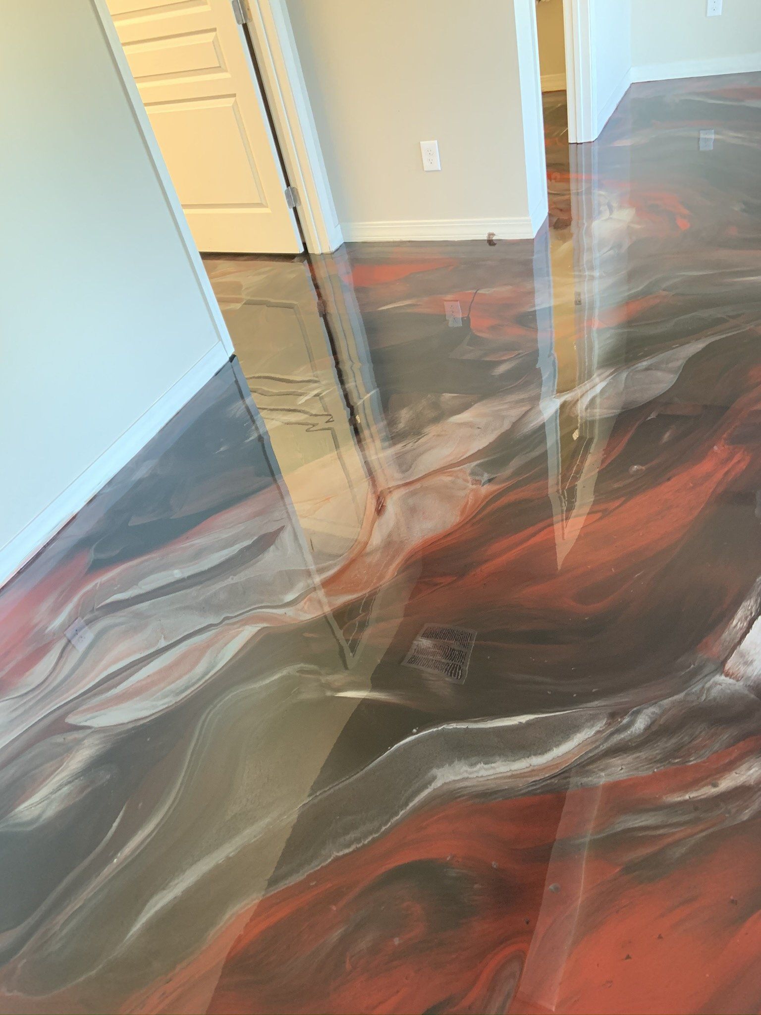 A shiny metallic floor in a room with a doorway.