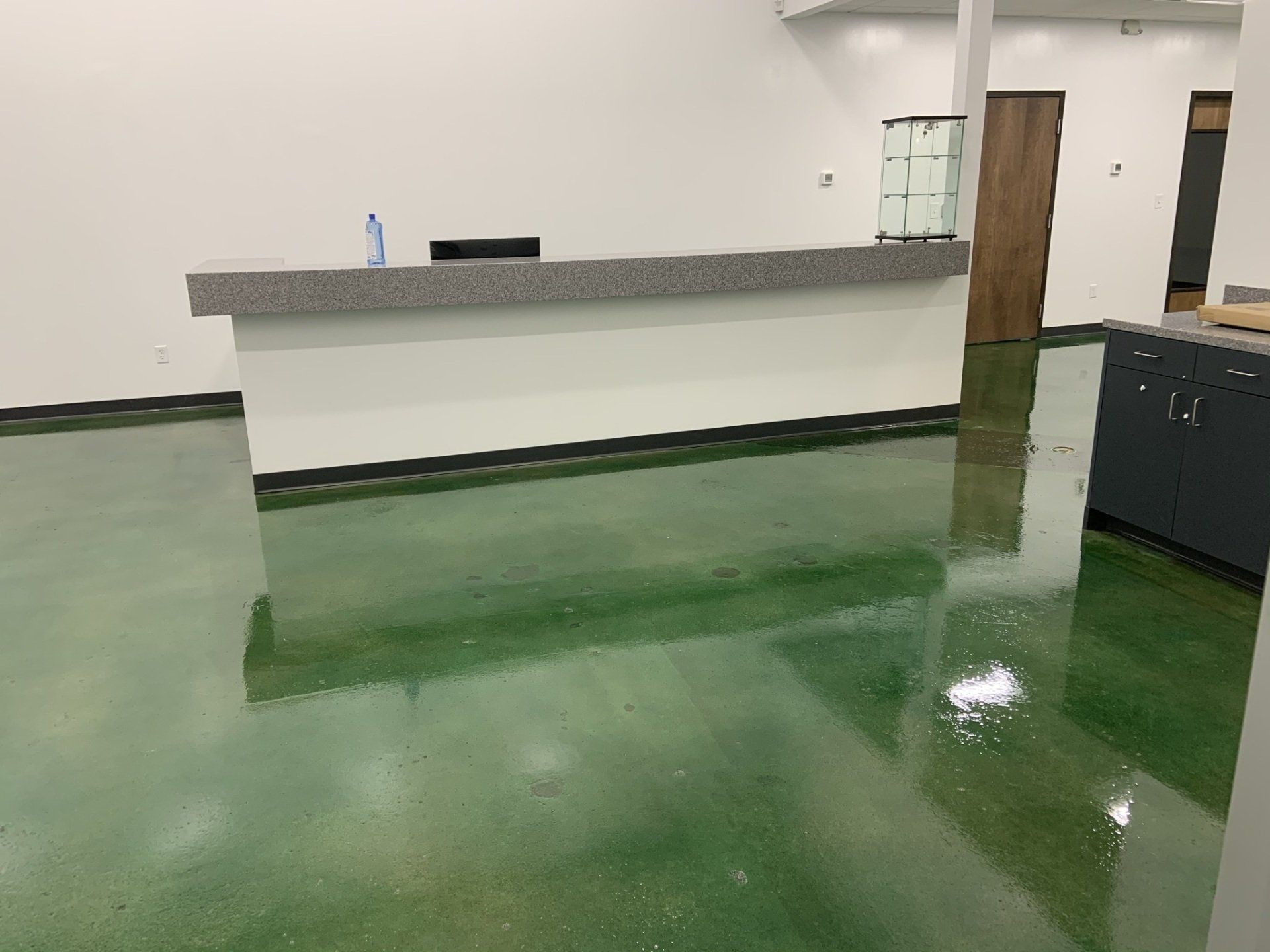 A room with a green floor and a white counter.