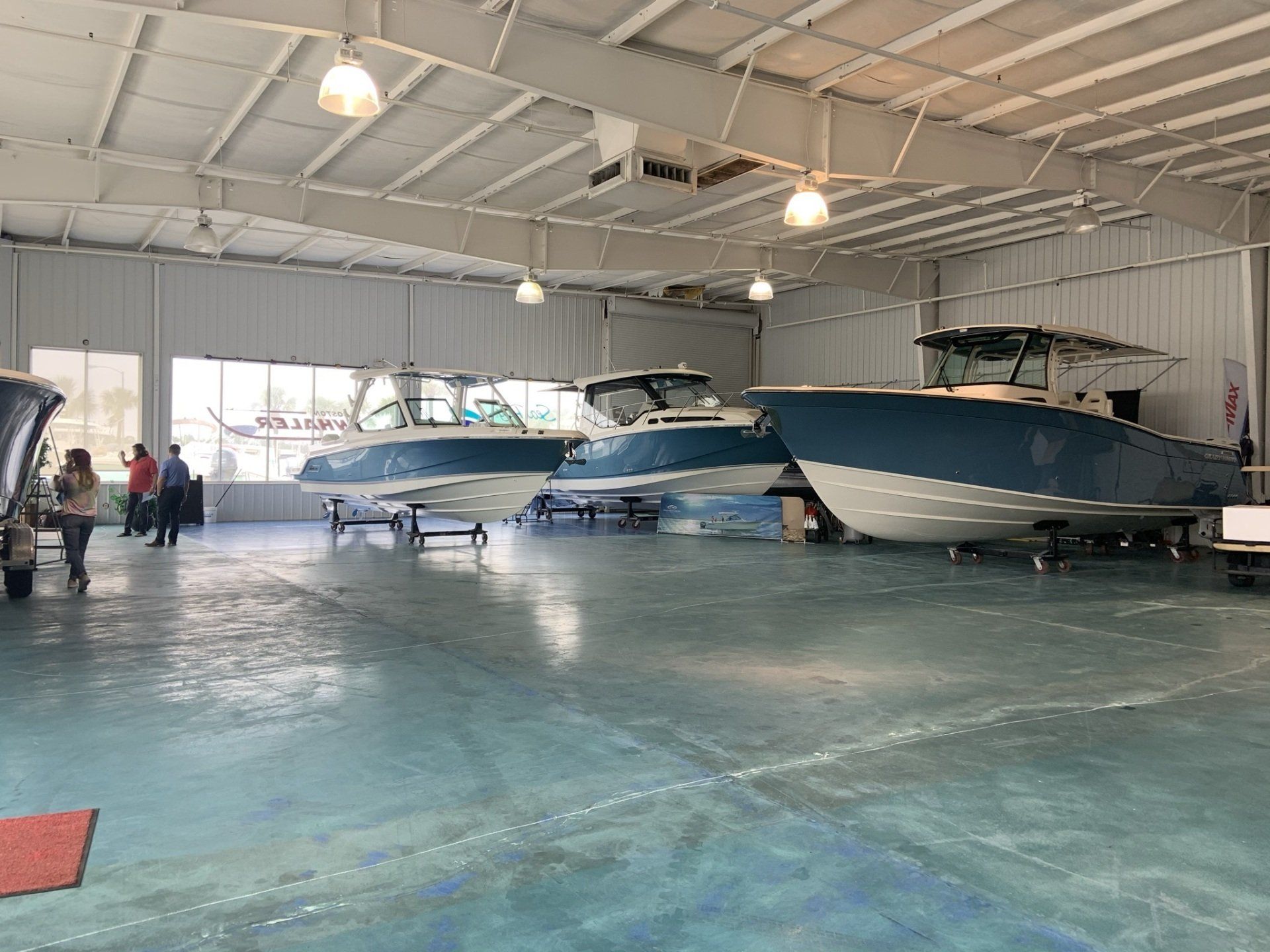 A large warehouse filled with boats and people.