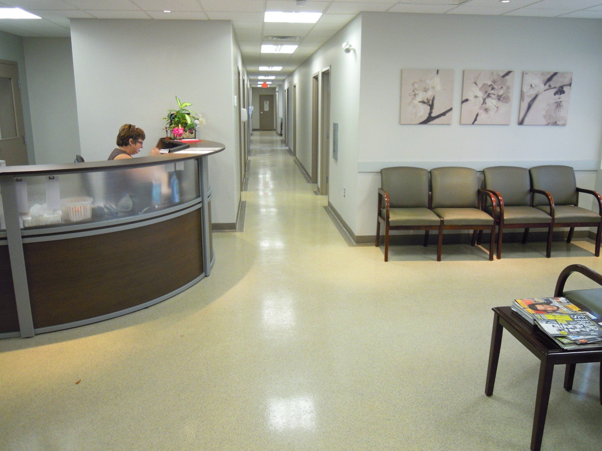 A woman sits at a desk in a hospital waiting room