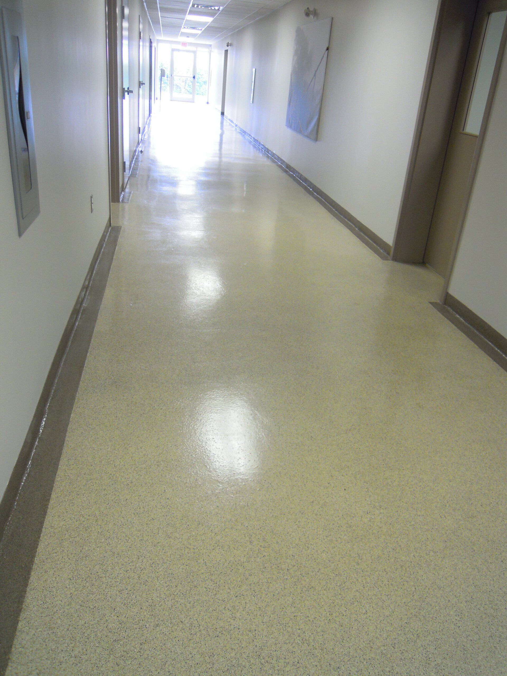 A long hallway with a shiny floor in a building.