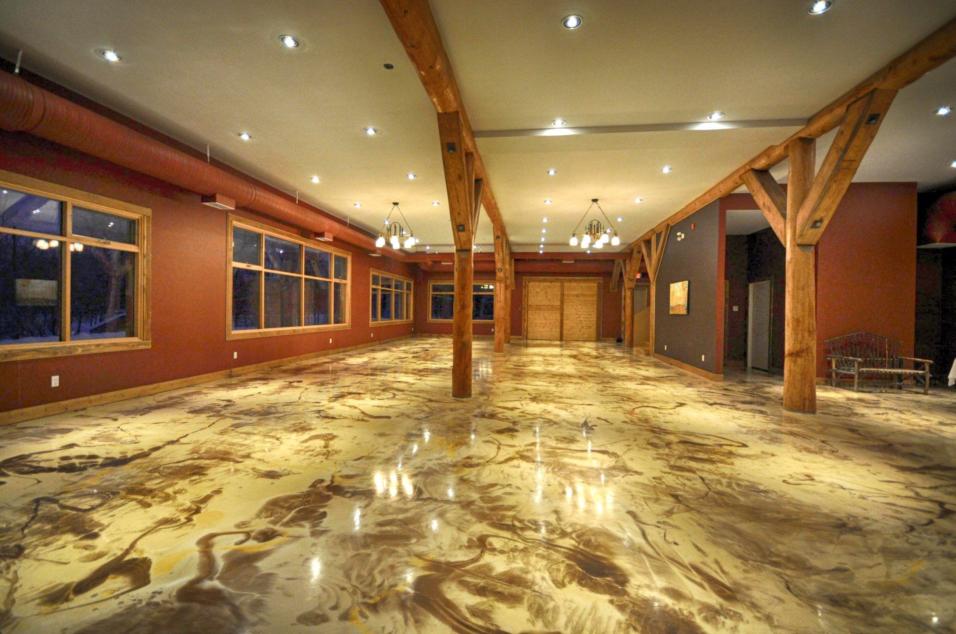 A large empty room with a marble floor and wooden beams.