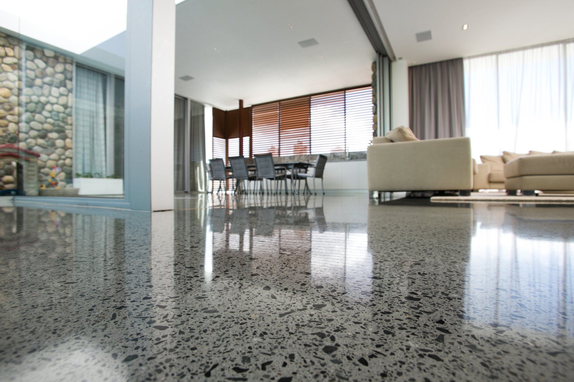 A living room with a shiny concrete floor