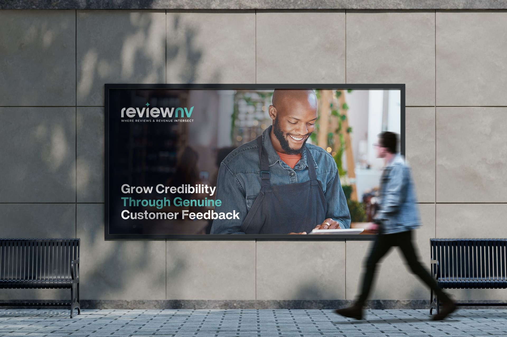 Billboard ad: Man walks past a reviewNW poster. Ad shows a smiling person and text about growing credibility through customer feedback.