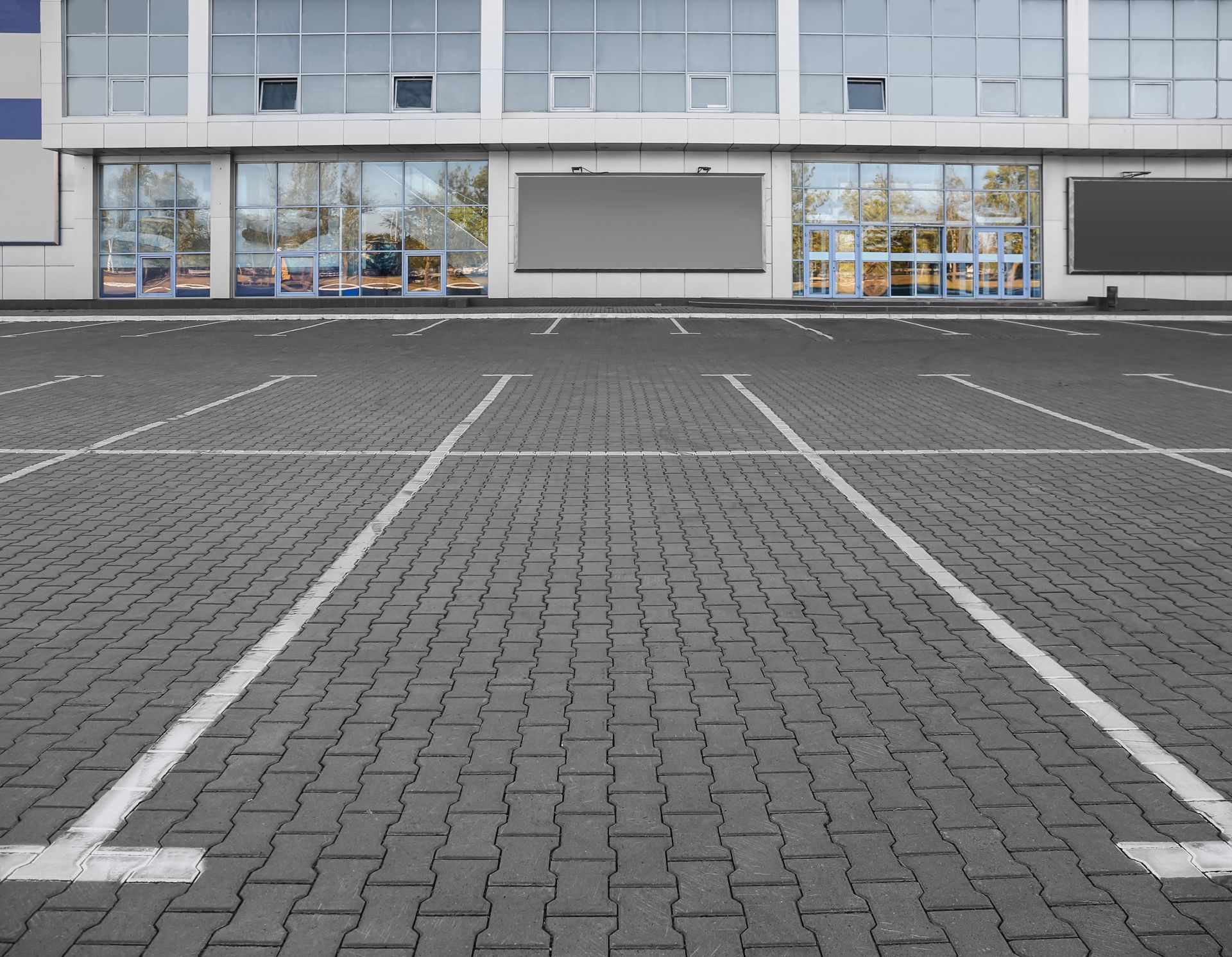 An empty parking lot with a building in the background
