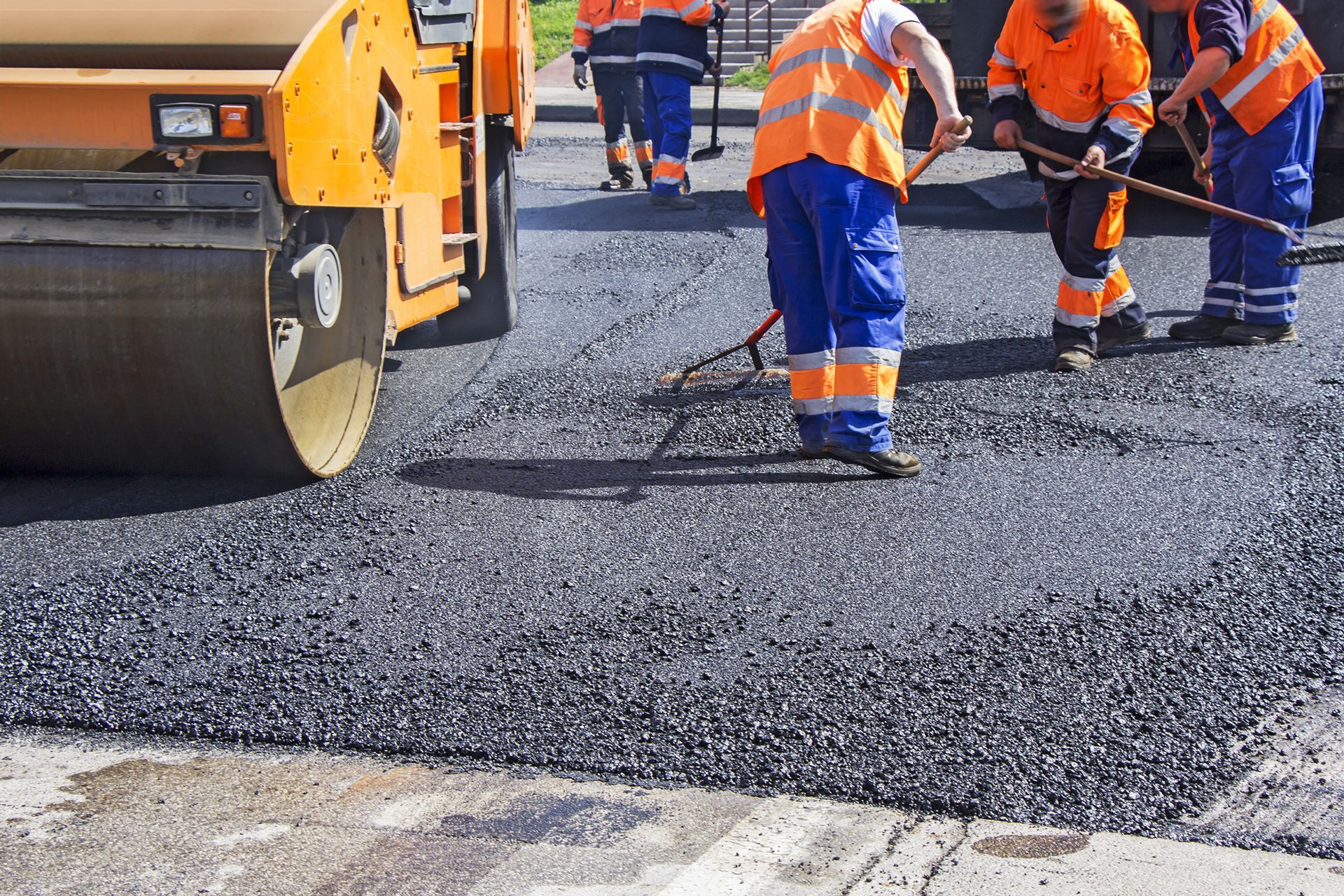 A group of construction workers are working on a road