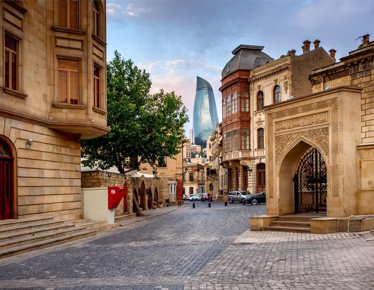 Tourists walking past the historic Maiden Tower in Baku Old City