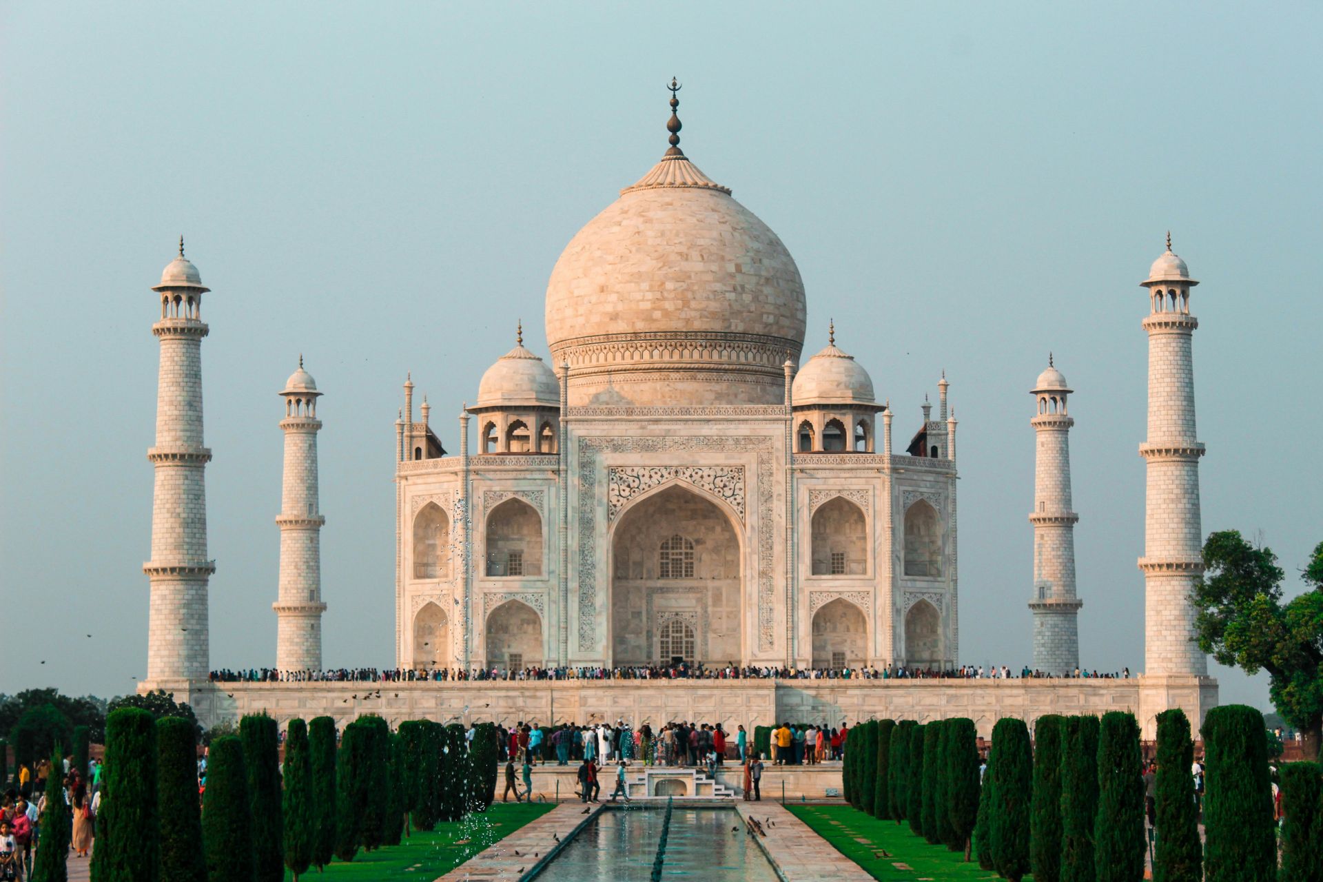 Taj Mahal, white marble mausoleum in Agra, India, with symmetrical design and four minarets.