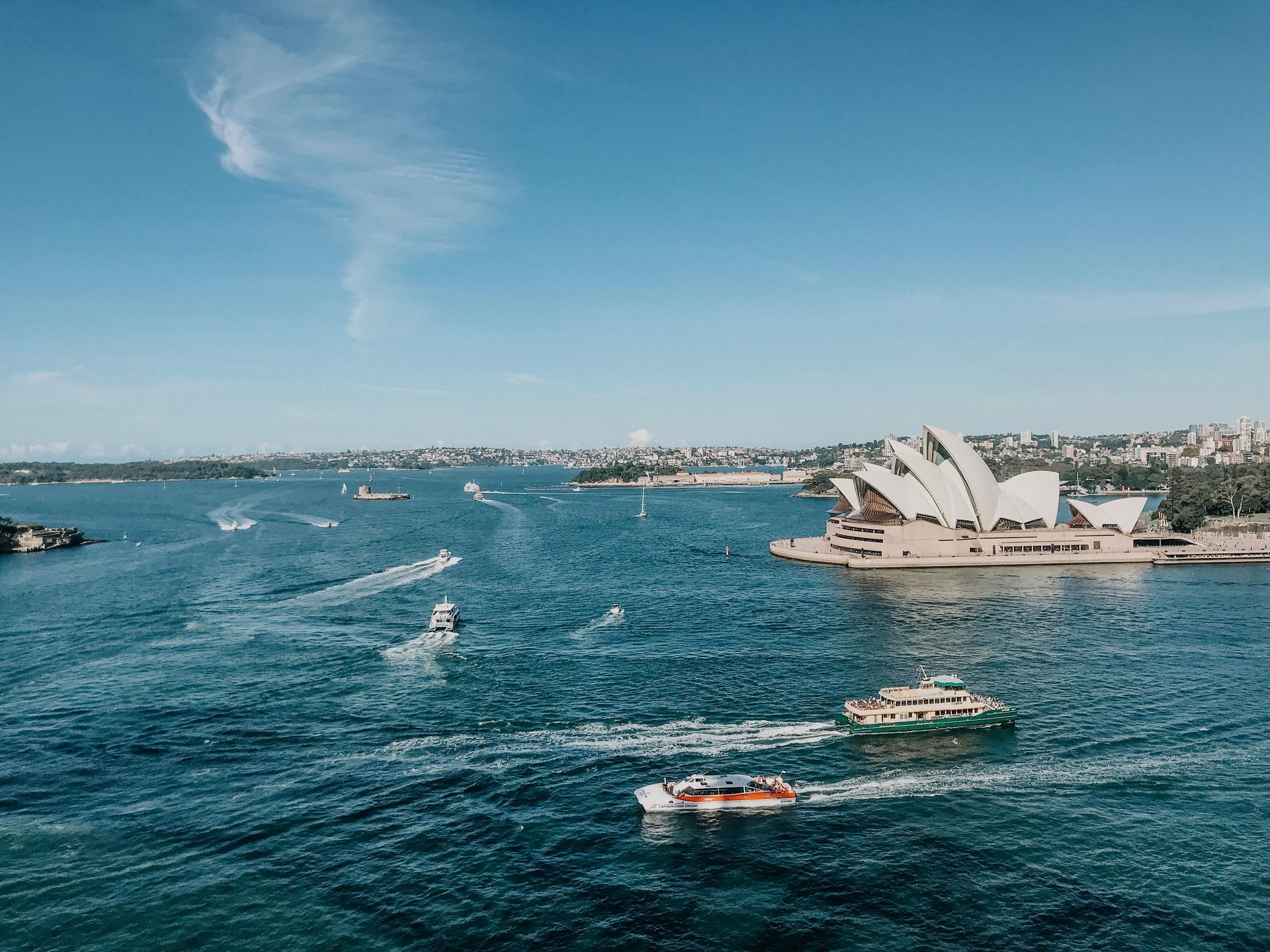 Sydney Harbour with the Opera House, boats, and clear blue sky.