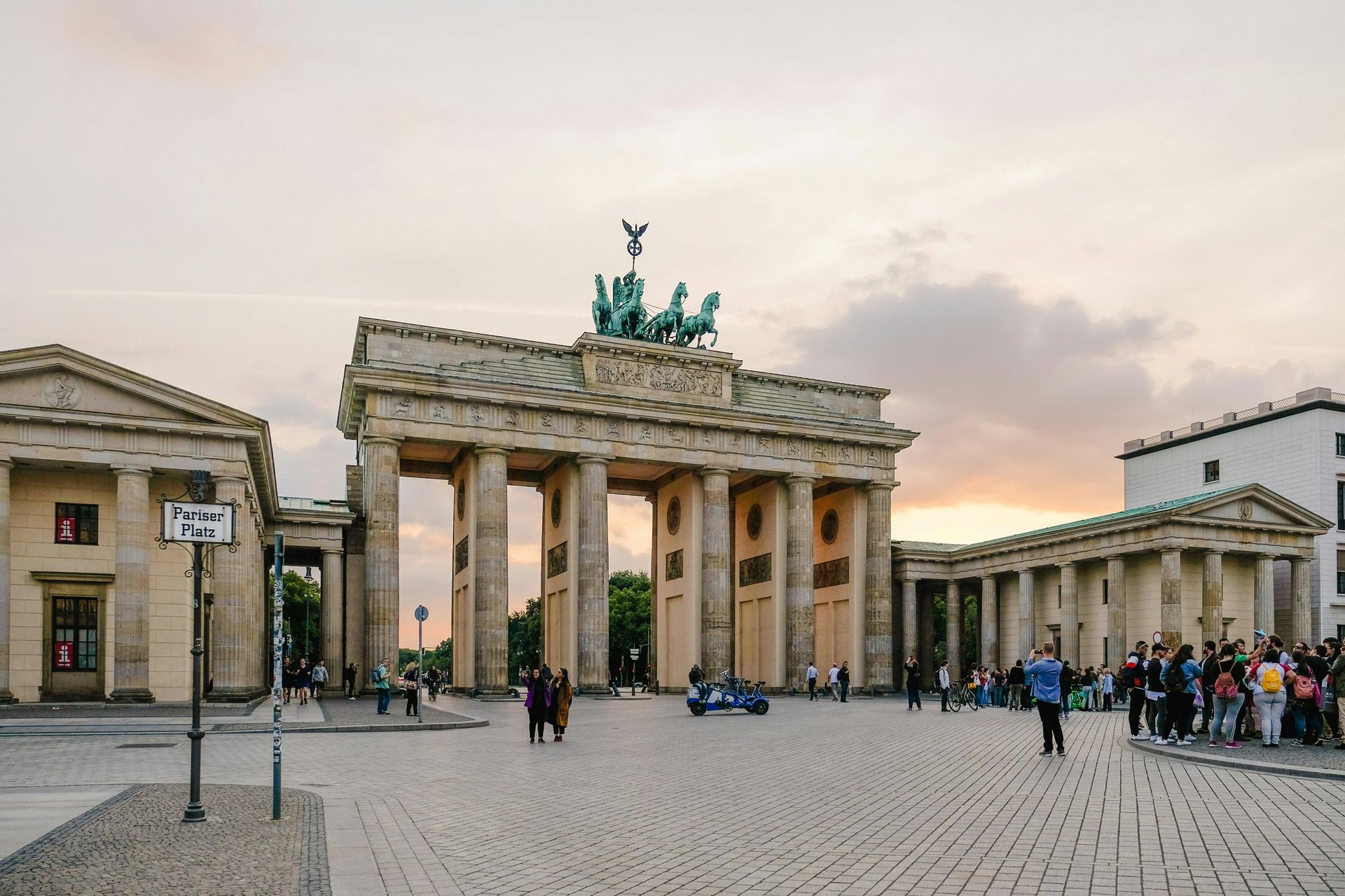 Brandenburg Gate in Berlin, Germany, a neoclassical monument with Quadriga statue. People walk around the square.