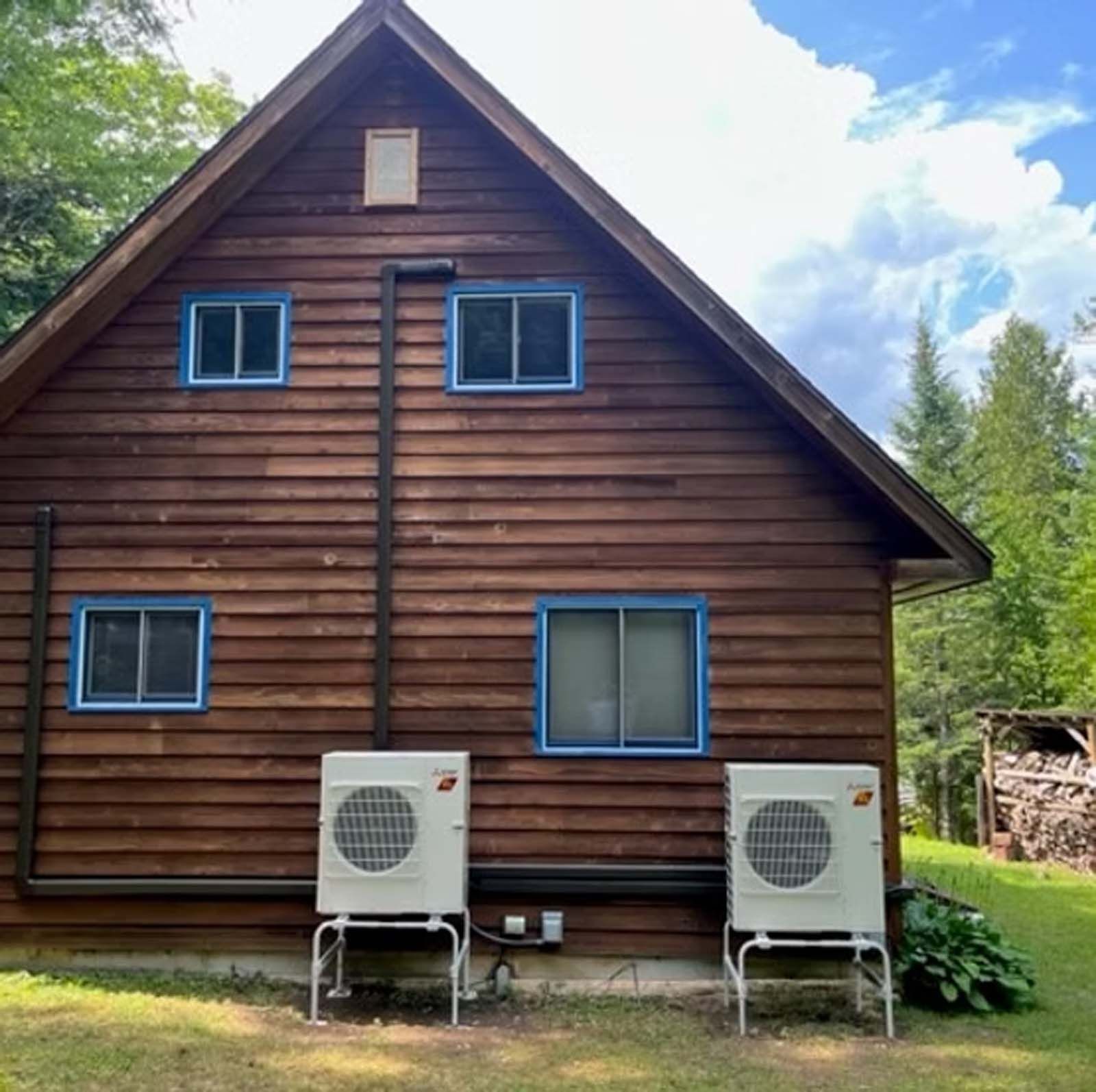 A wooden house with two air conditioners on the side