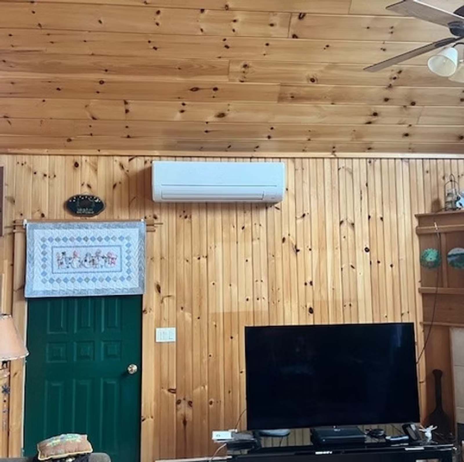 A living room with wood paneling and a flat screen tv
