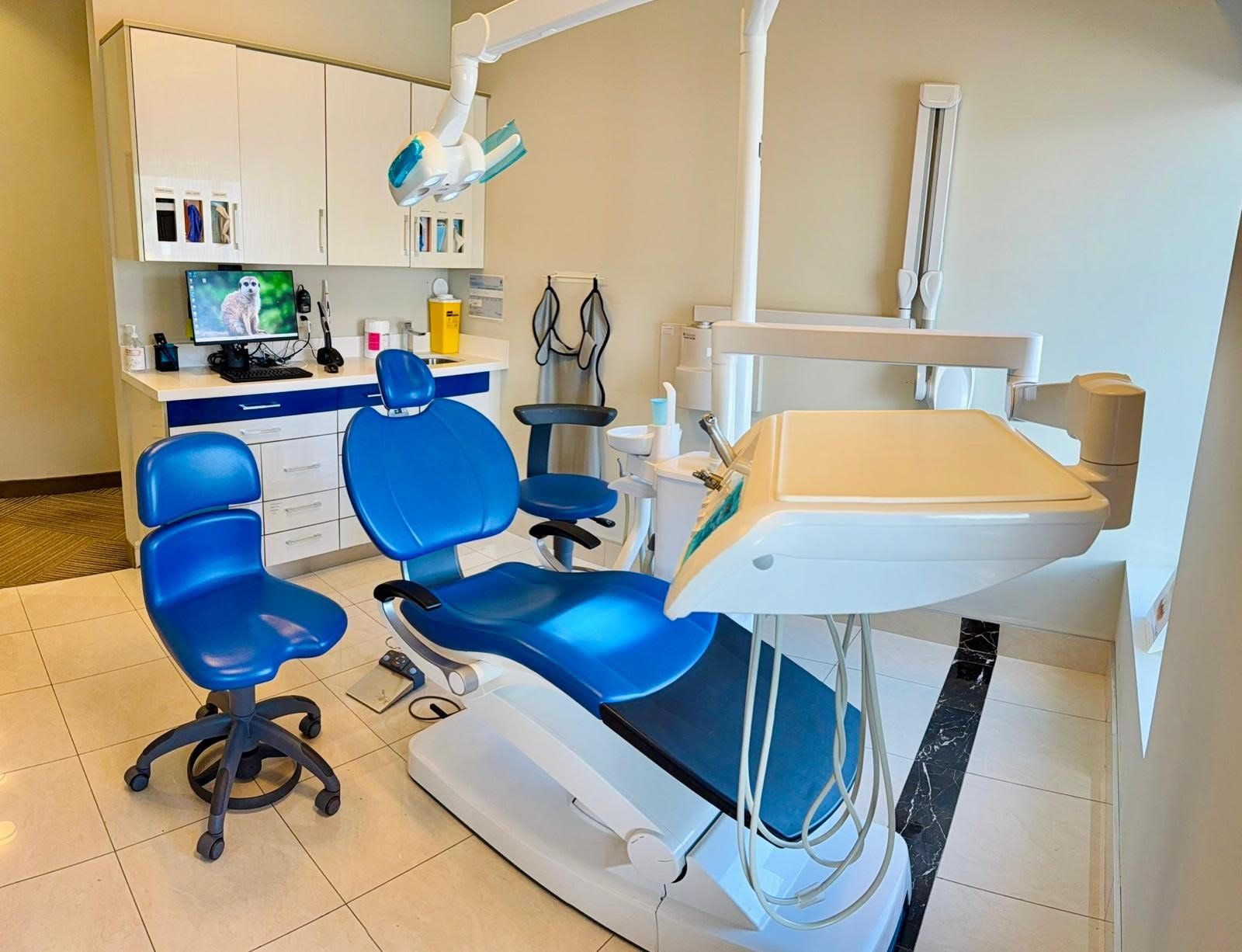 A dental office with blue chairs and a dental chair