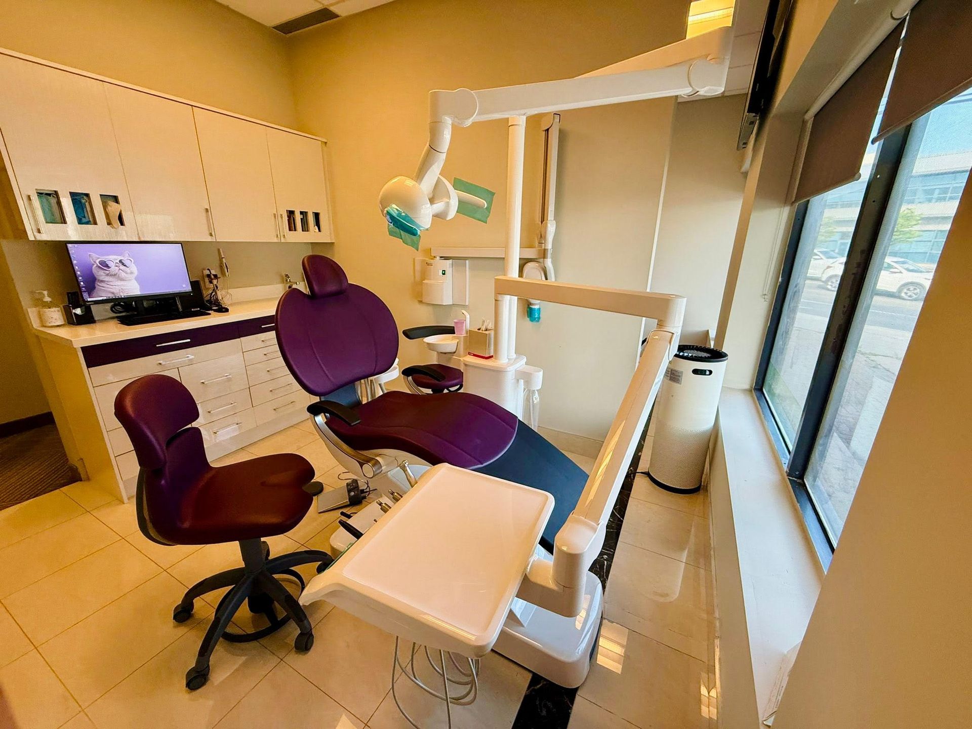 A dental office with a purple chair and a computer.