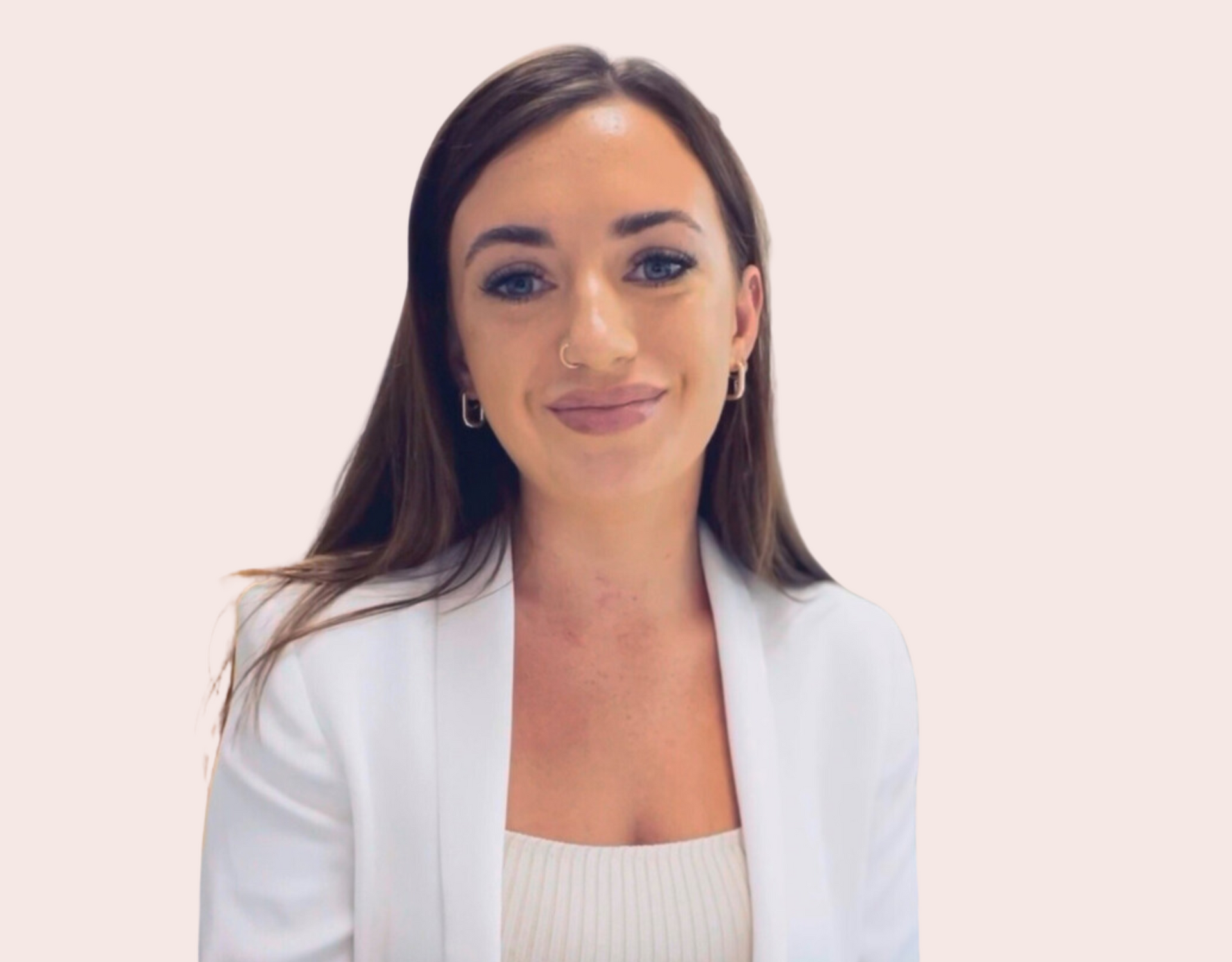 A woman wearing a white jacket and earrings is smiling for the camera.