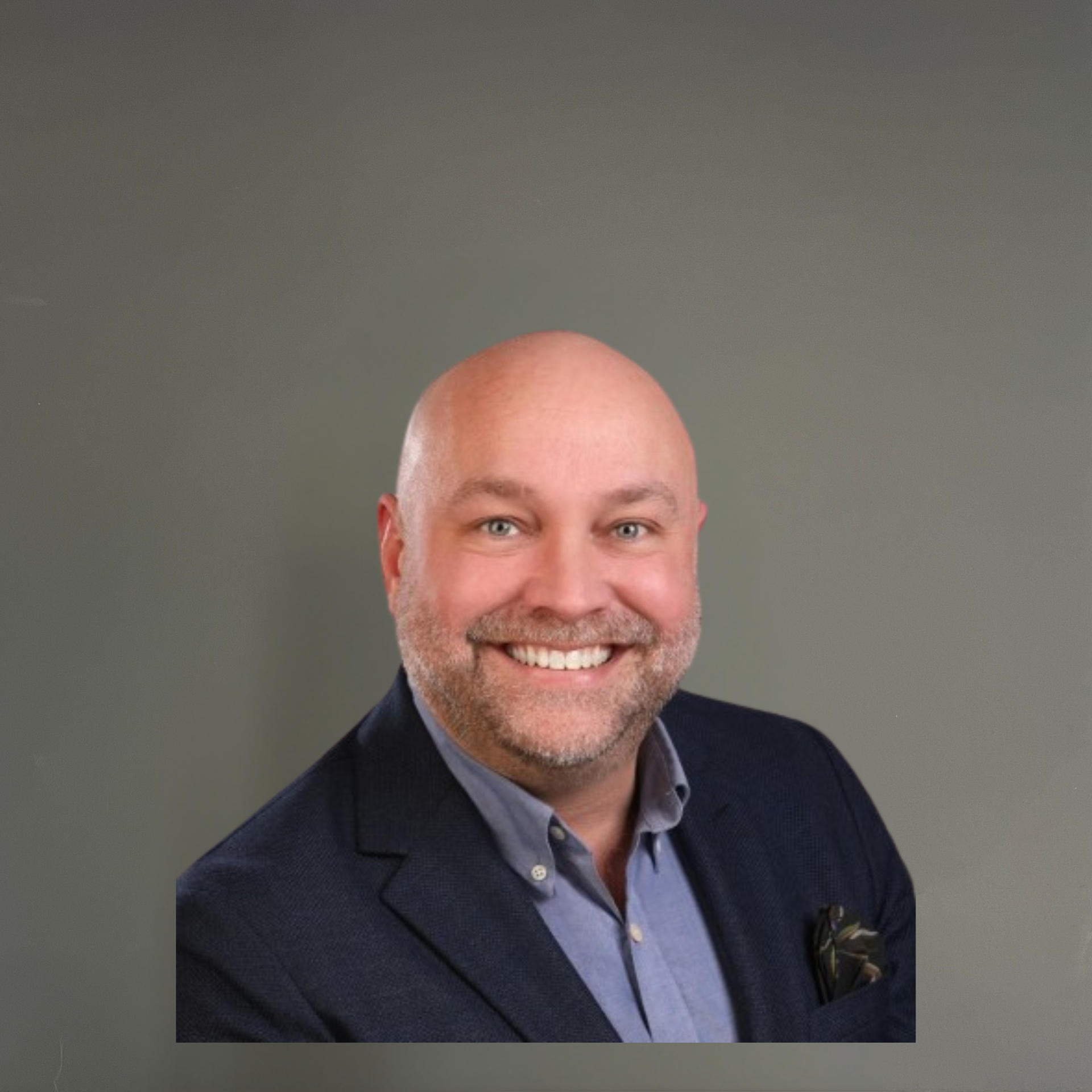A bald man with a beard wearing a suit and smiling