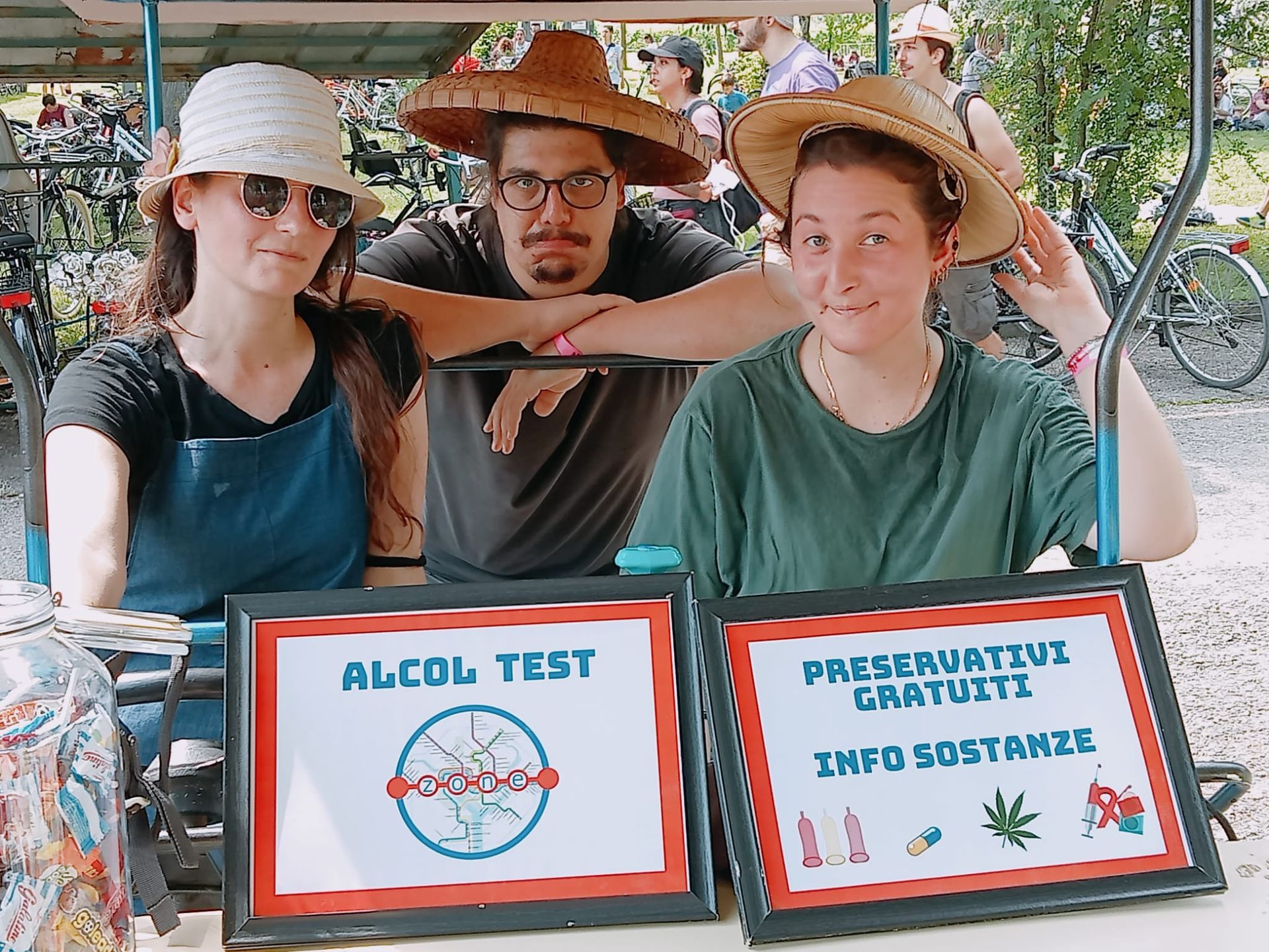 Tre persone in uno stand all'aperto che offrono test gratuiti sull'alcol e informazioni sulle sostanze.
