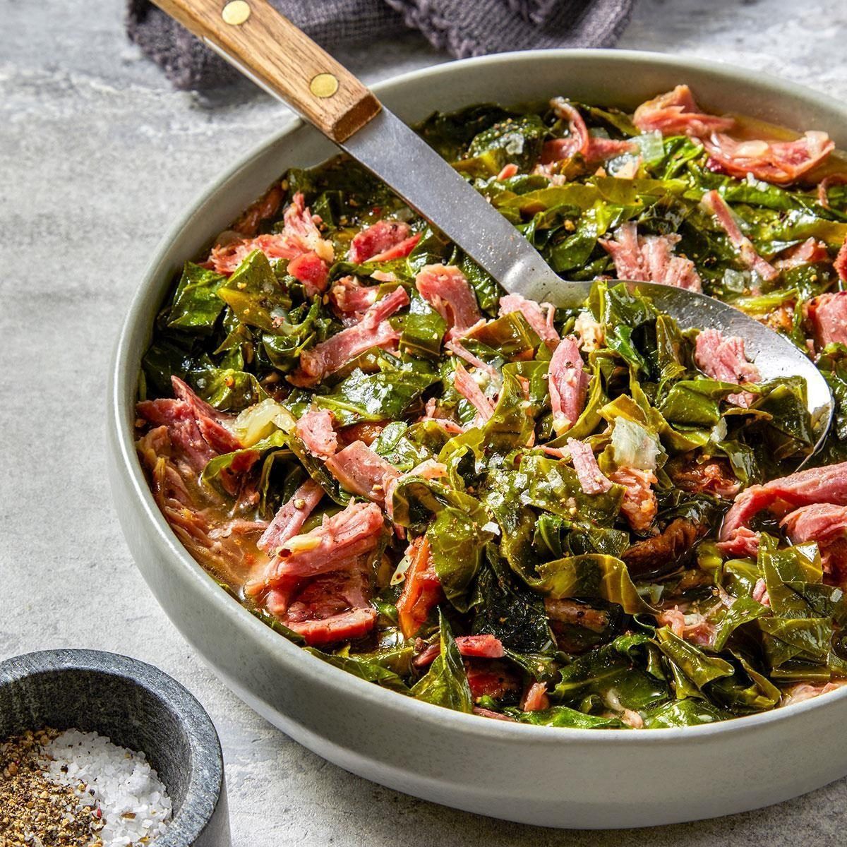 Bowl of collard greens with smoked turkey, with serving spoon.