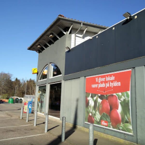a sign on the side of a building says vi giver lokale varer plads på hylden