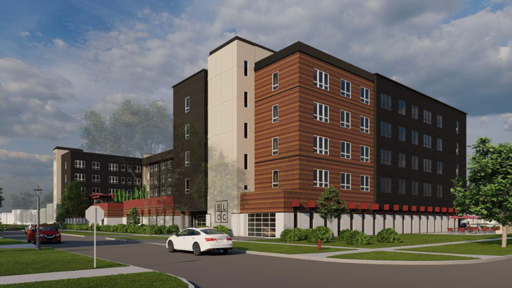 Rendering of a modern multi-story apartment building with a mix of brown, black, and white siding, on a street corner with cars.