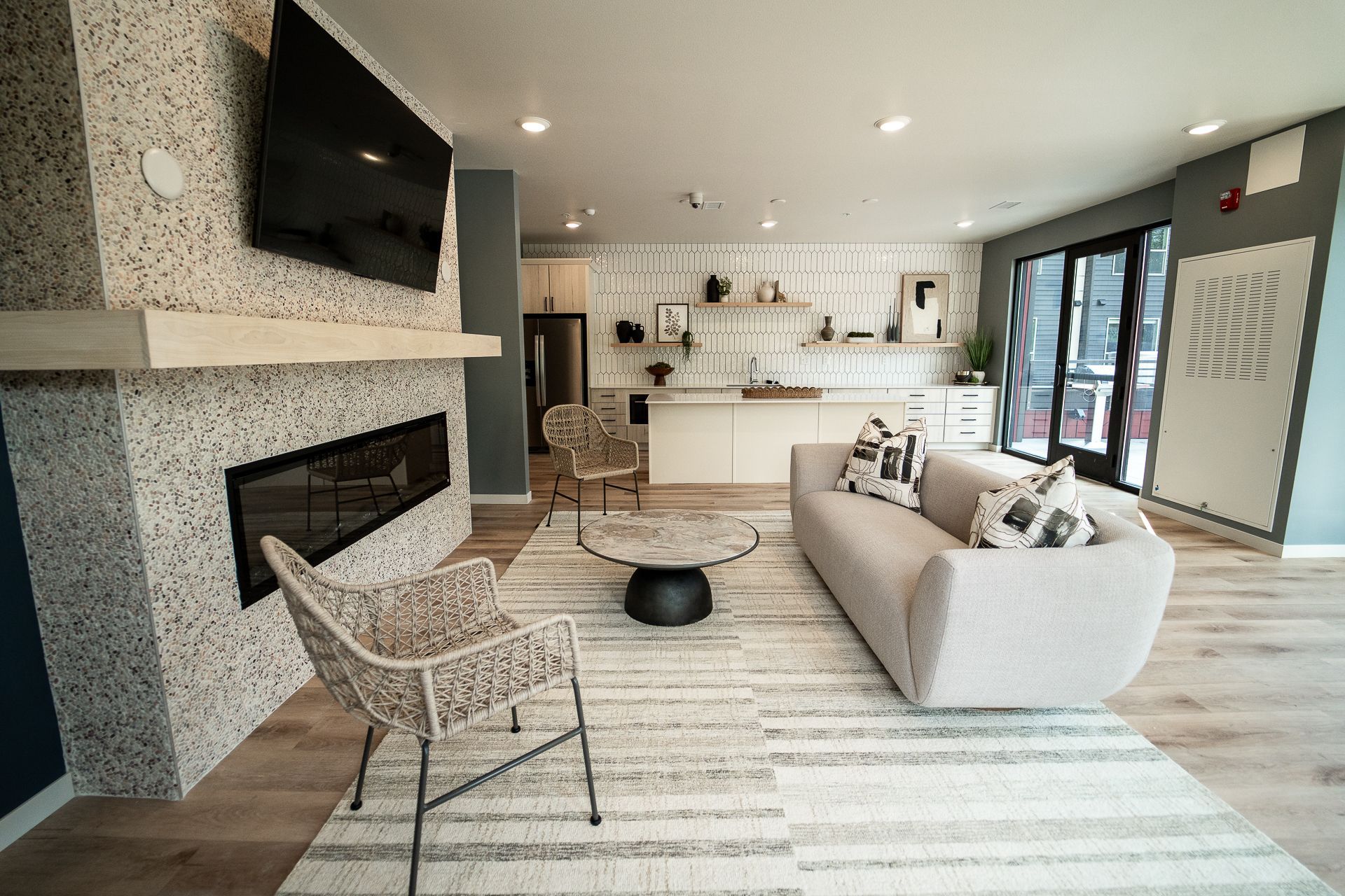 Living room with stone fireplace, wooden accents, TV, black armchair, and red paper lanterns.