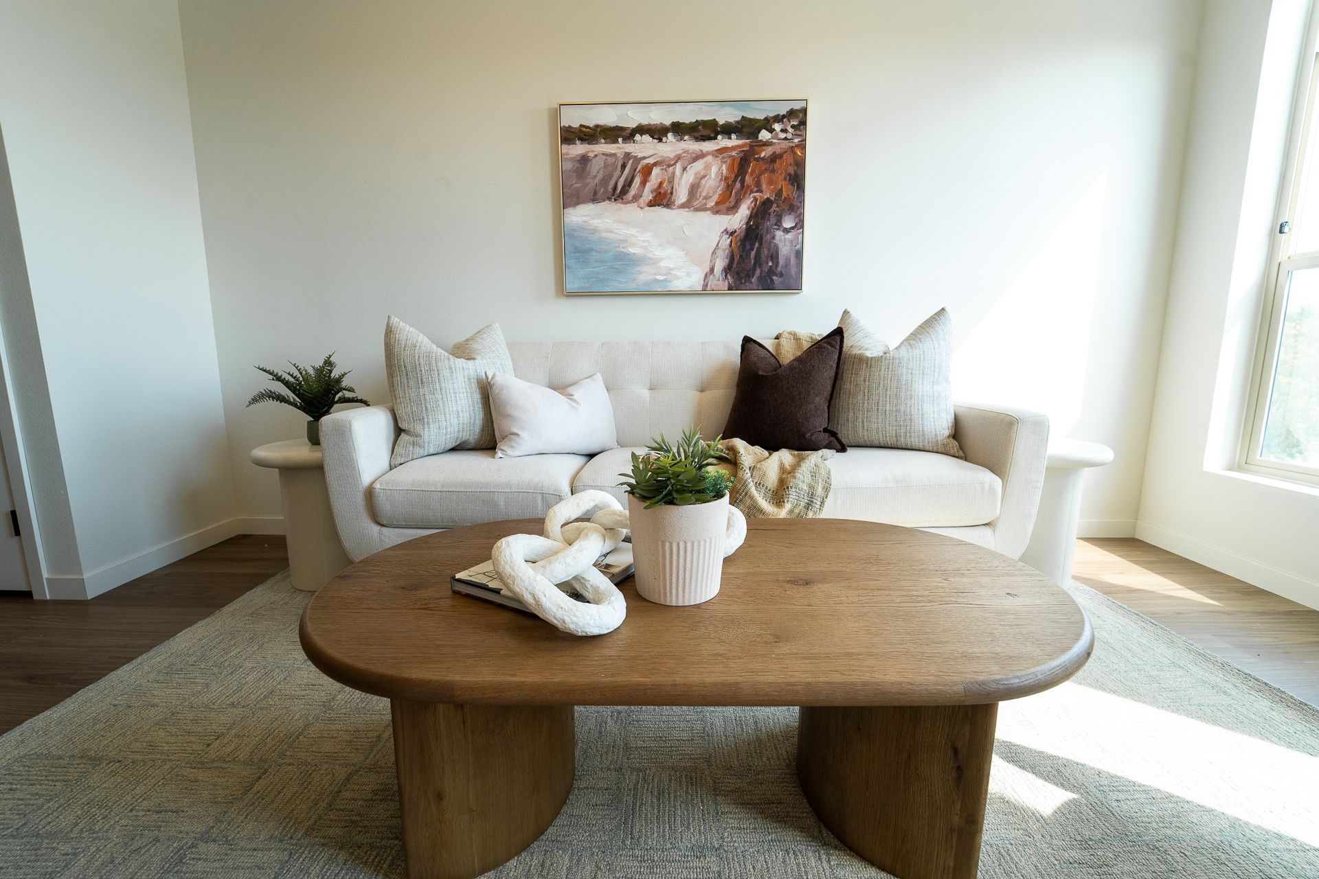 Living room overstuffed couch, natural wood coffee table, decorative accents, and tasteful artwork