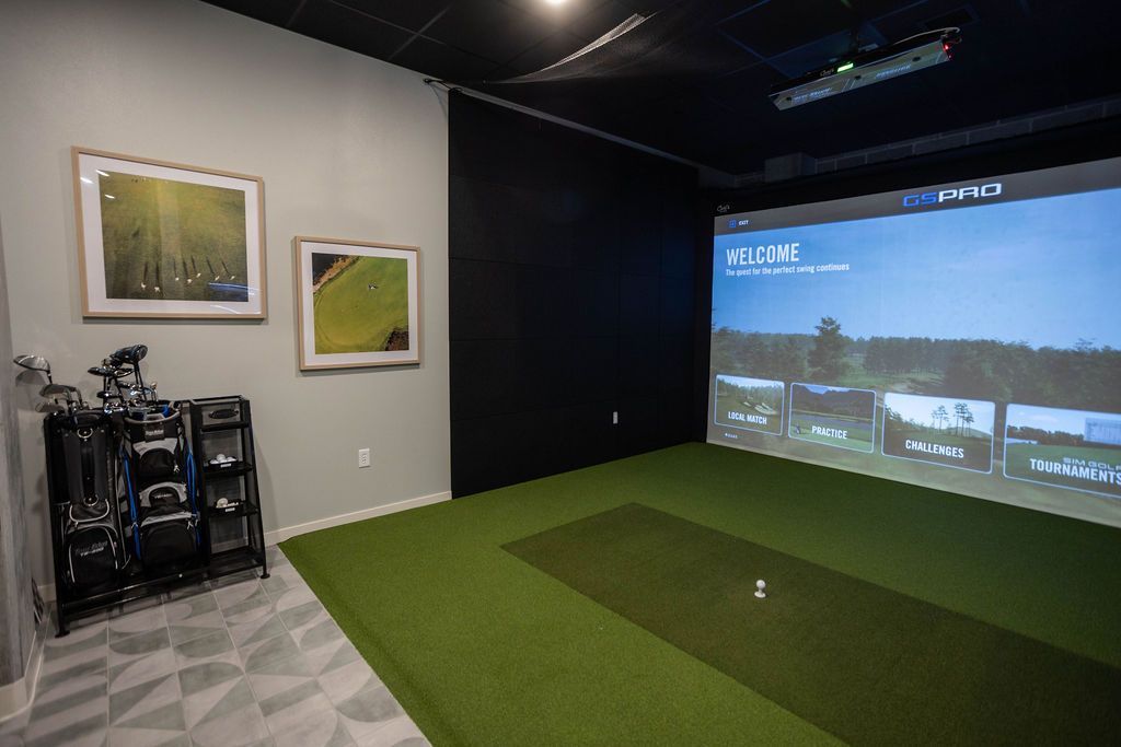 A modern rec room featuring a pool table, sofa, fireplace, and built-in shelving unit. People are seen interacting in the space.