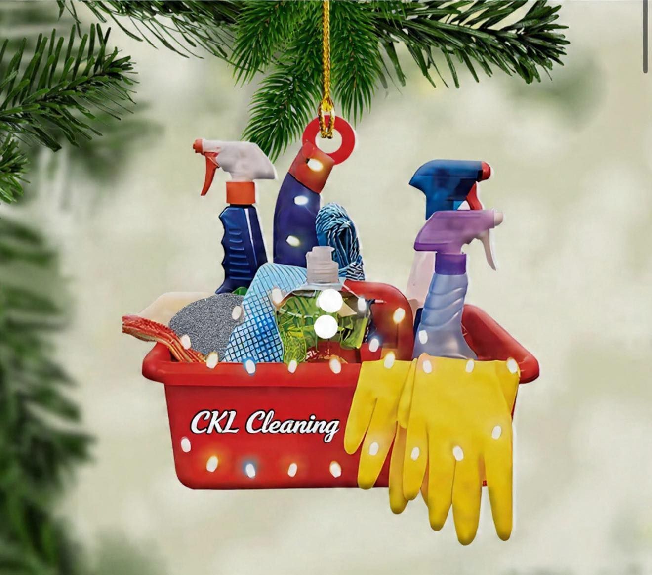 Christmas ornament of a red cleaning caddy labeled “CKL Cleaning,” filled with spray bottles, gloves, and cloths