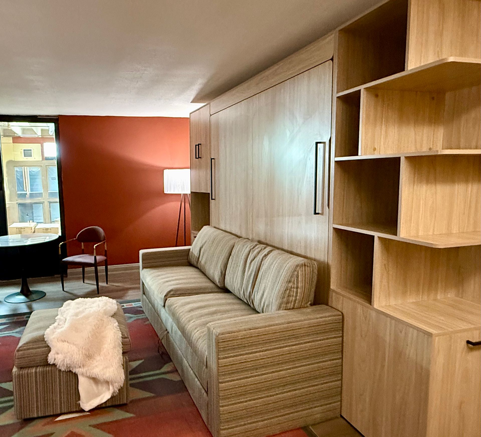 Photo showing a couch with a custom built surrounding that has built-in shelving