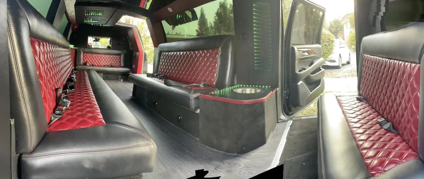 The inside of a limousine with red and black seats.