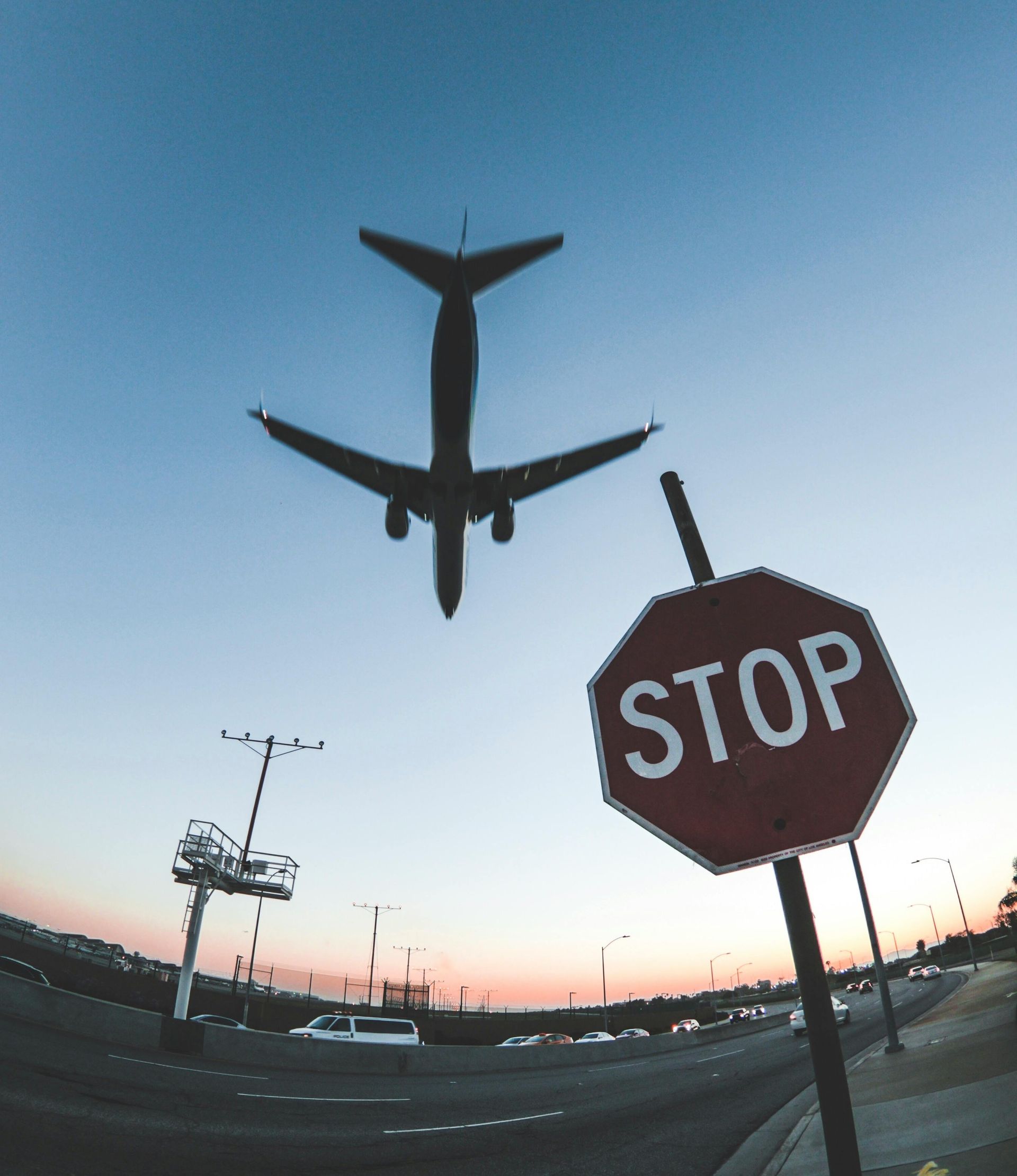An airplane is flying over a stop sign