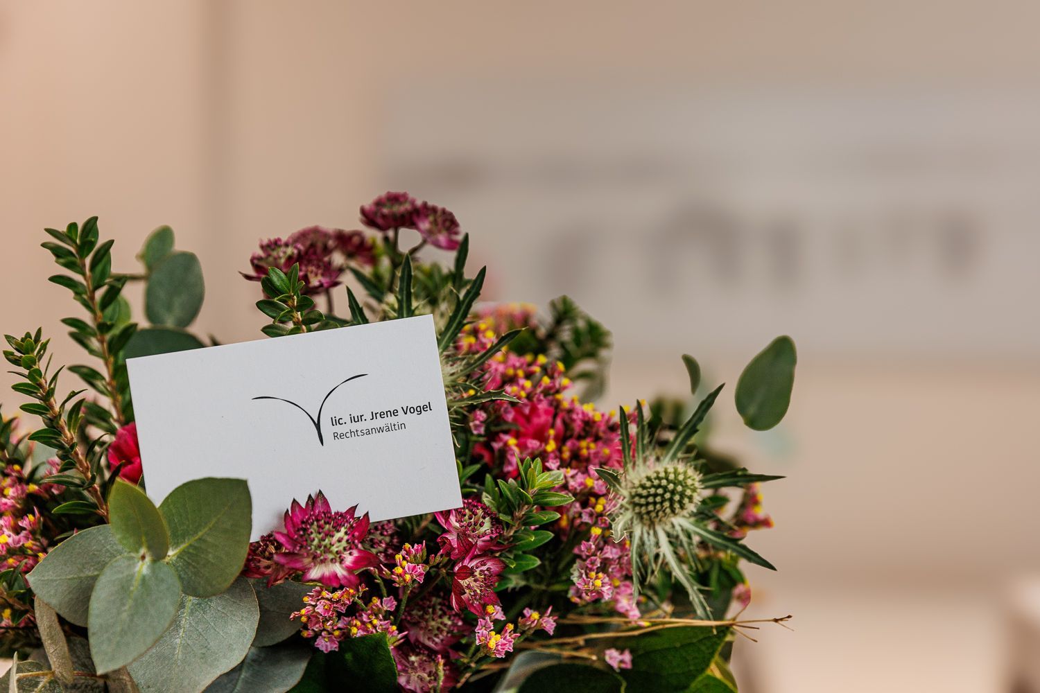 Auf einem Holztisch steht eine Vase mit Blumen.