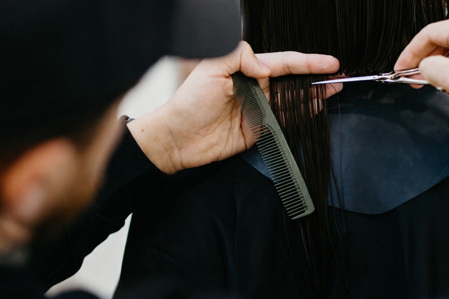 Donna con capelli scuri, testa reclinata all'indietro, capelli fluenti che svettano su uno sfondo bianco.