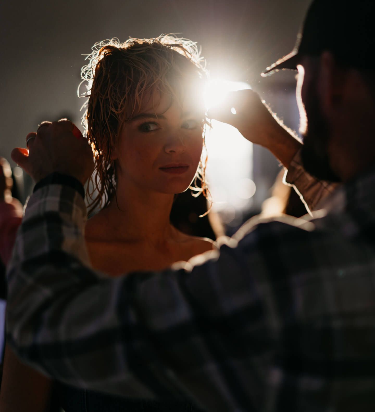 Donna con lunghi capelli ondulati, con un top nero testurizzato, che guarda direttamente l'osservatore. Bianco e nero.