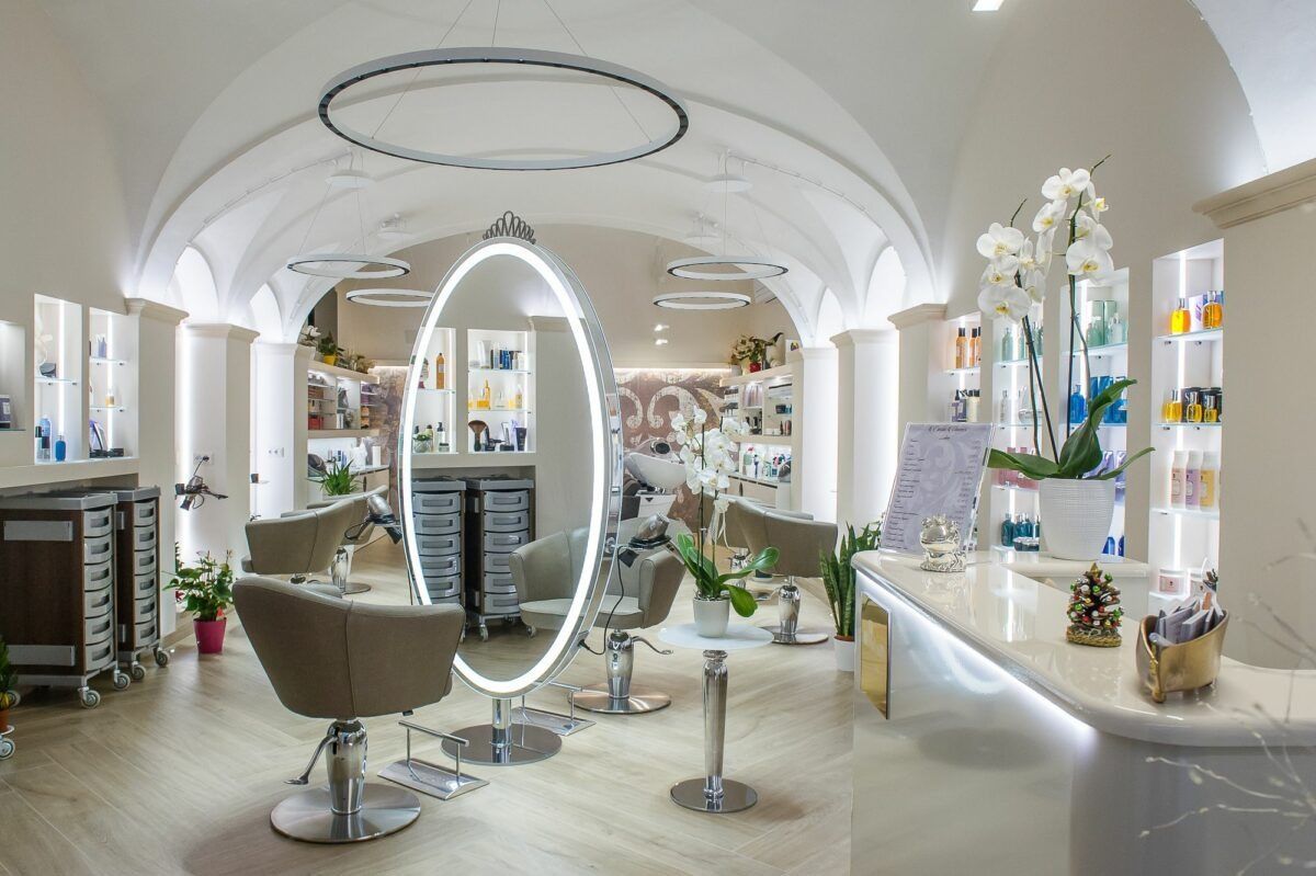 Elegante interno di un salone da parrucchiere con specchi, sedie ed espositori per i prodotti.