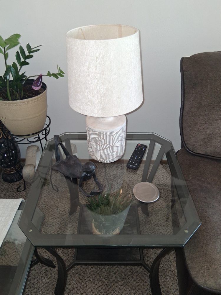 A lamp is sitting on a glass table in a living room