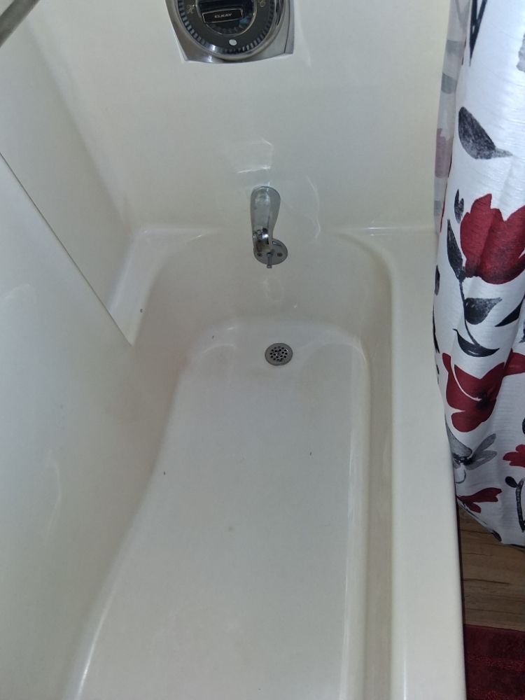 A bathtub in a bathroom with a shower curtain.