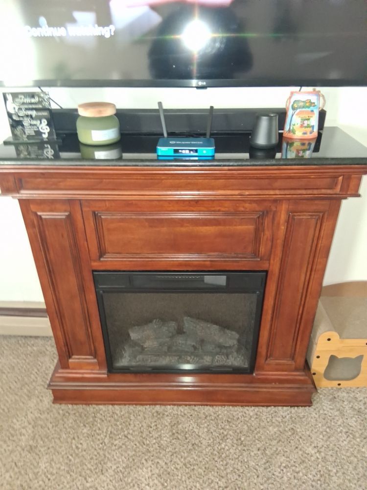 A fireplace with a tv on top of it and a router on top of it.