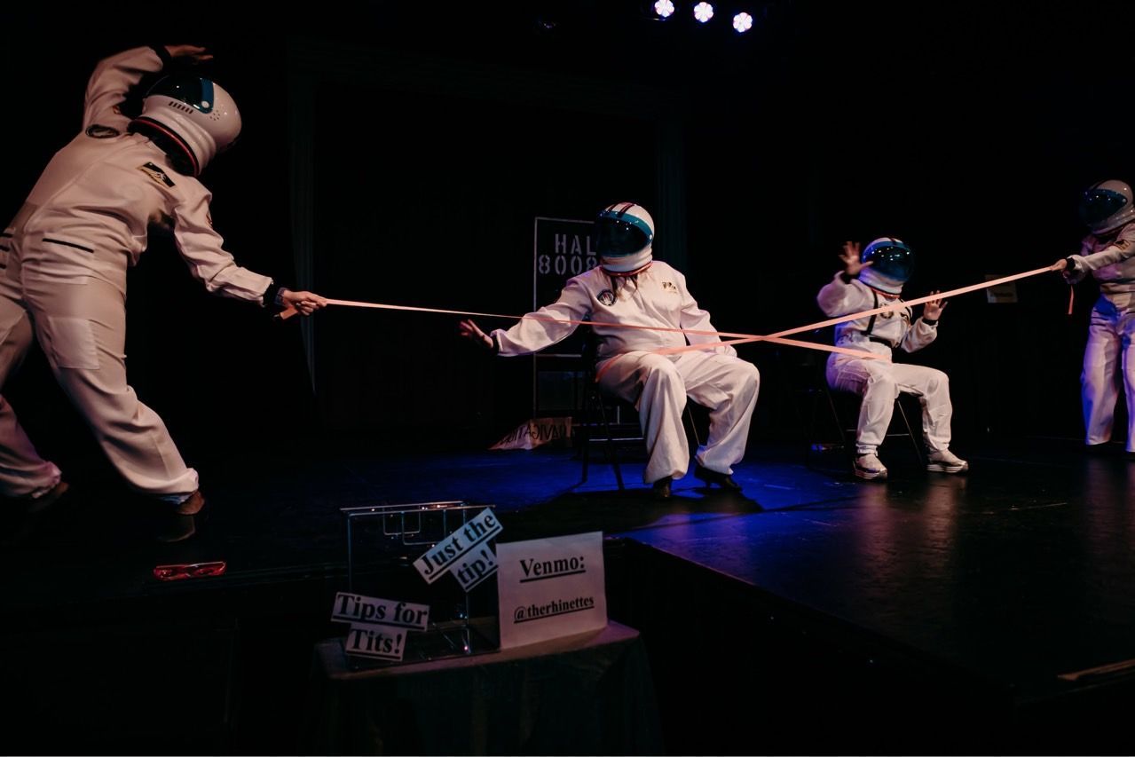 A group of people are playing a game of fencing on a stage.