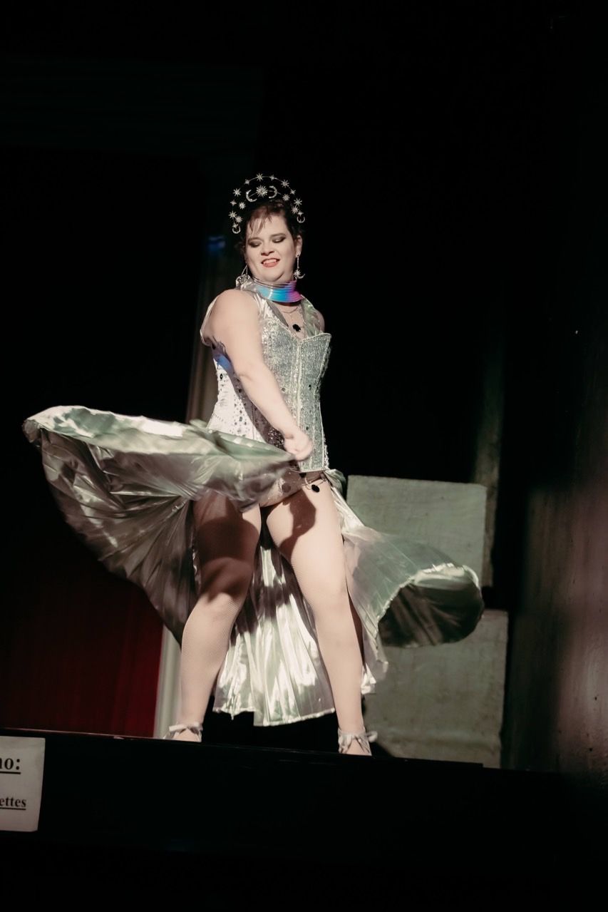 A woman in a dress is dancing on a stage.