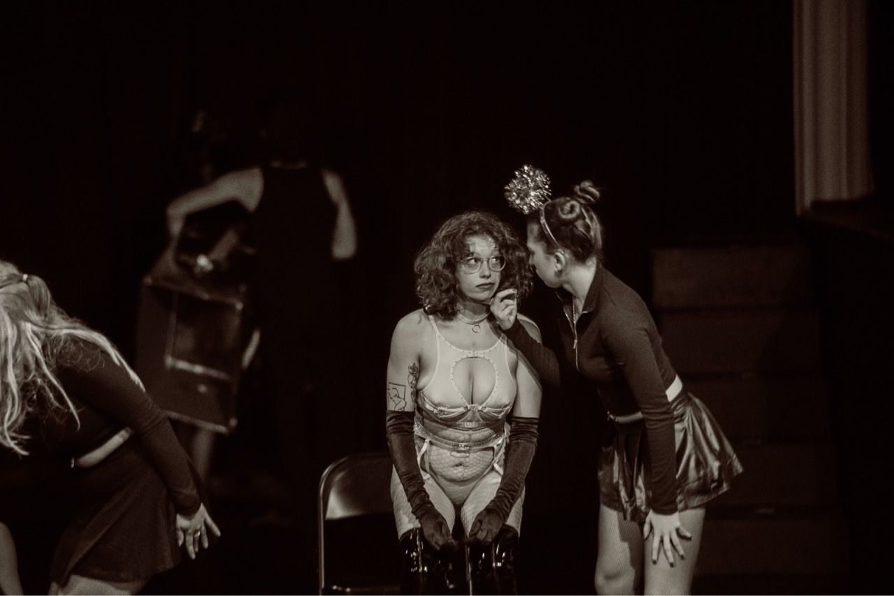 Two women are standing next to each other on a stage in a black and white photo.